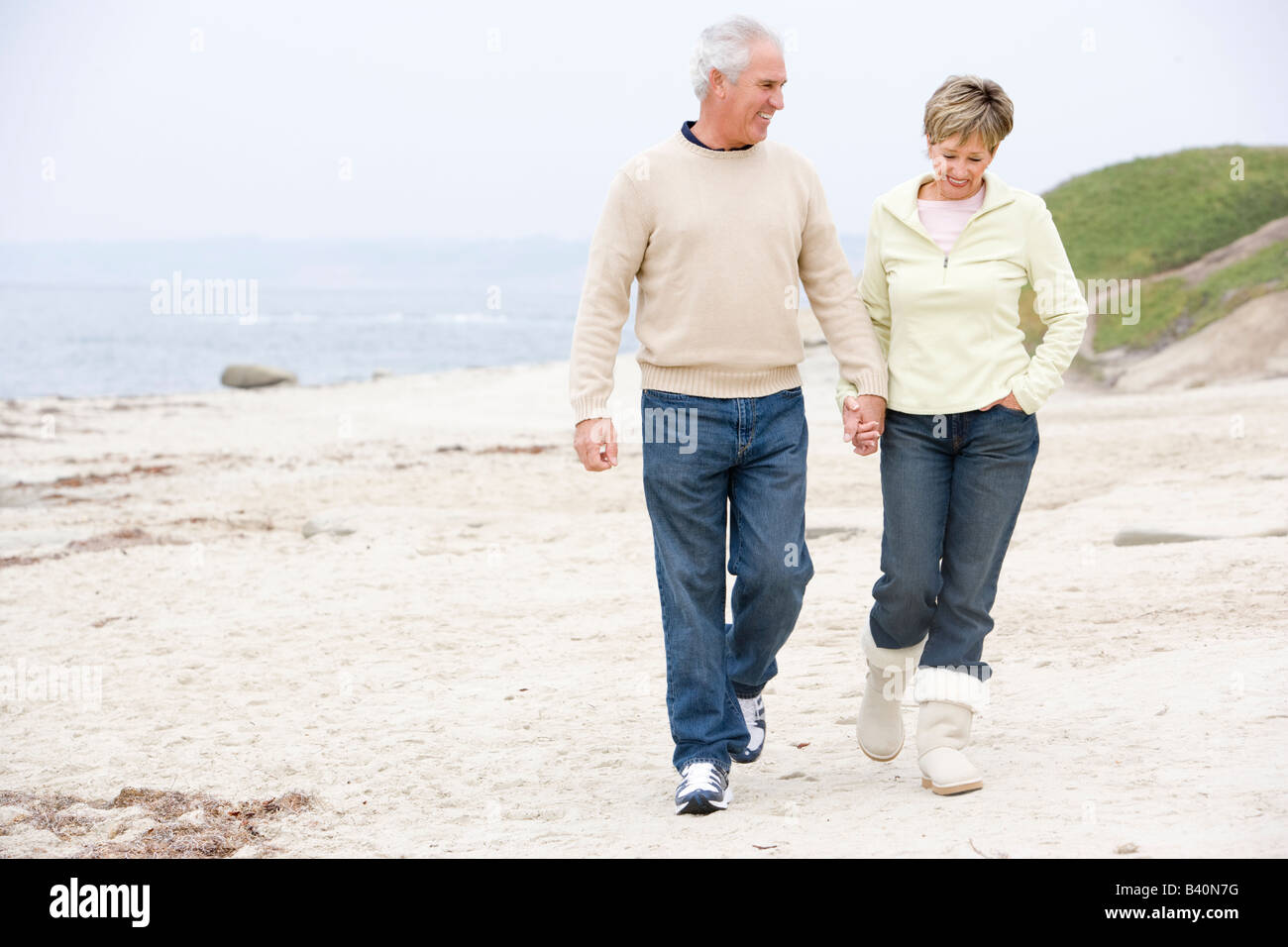 Couple at the beach holding hands and smiling Stock Photo - Alamy