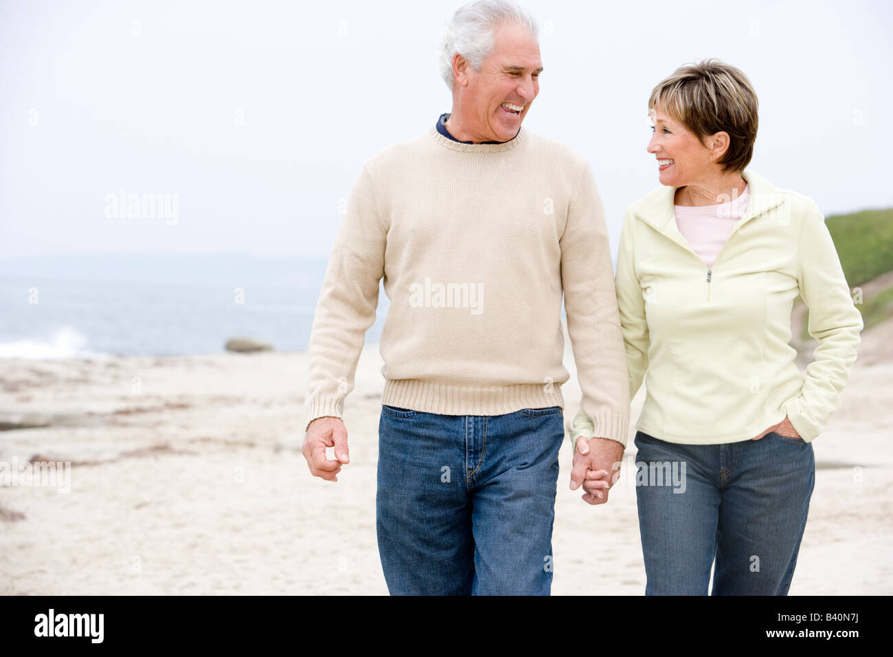 Couple at the beach holding hands and smiling Stock Photo - Alamy
