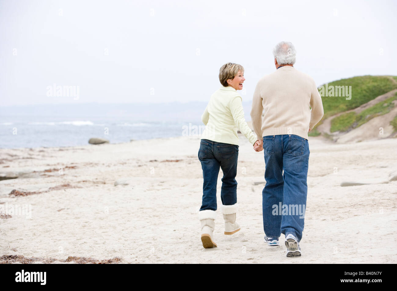 Couple at the beach holding hands and smiling Stock Photo - Alamy