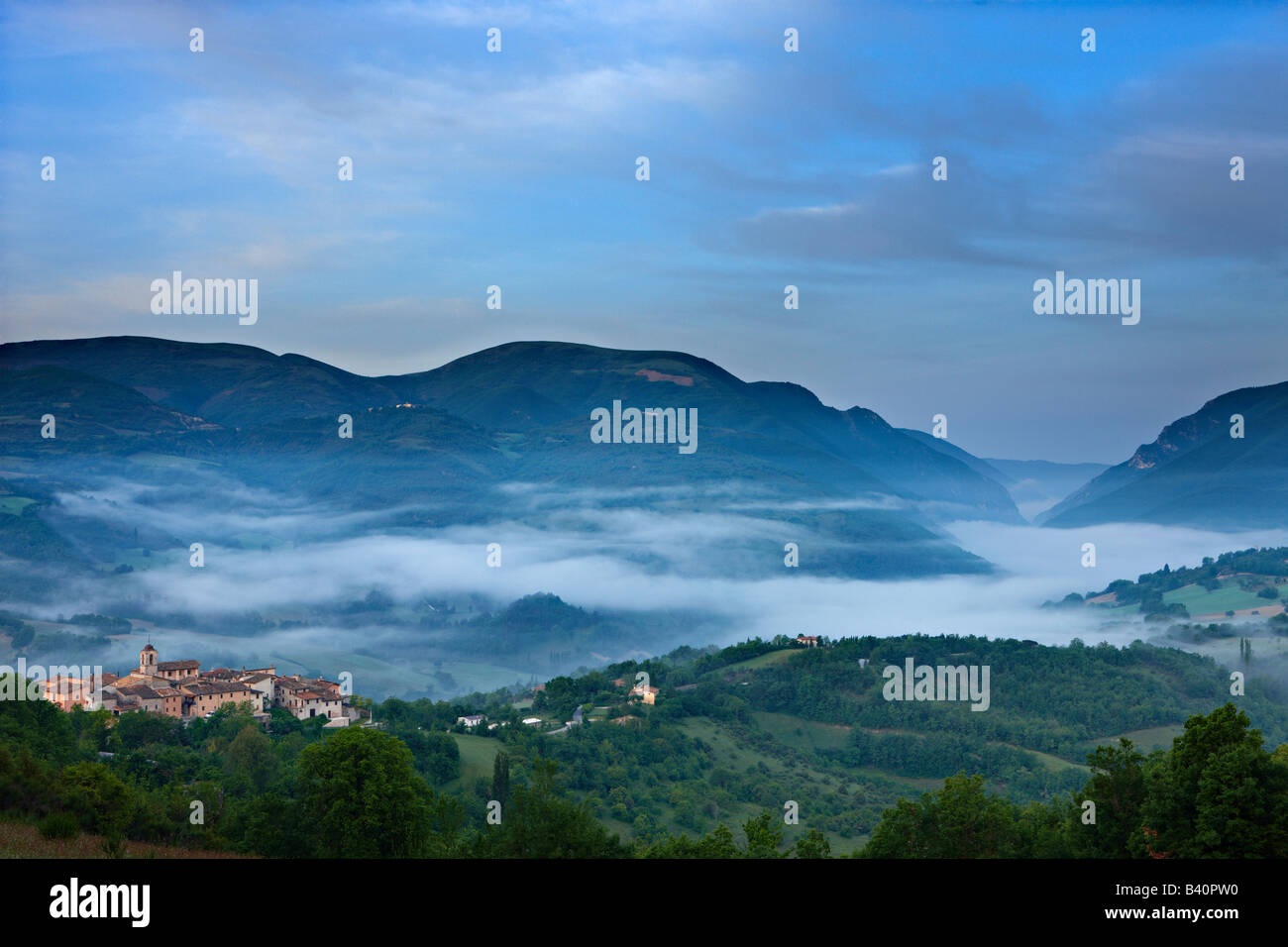 the village of Castelvecchio with mist lying in the Valnerina at dawn, Umbria, Italy Stock Photo