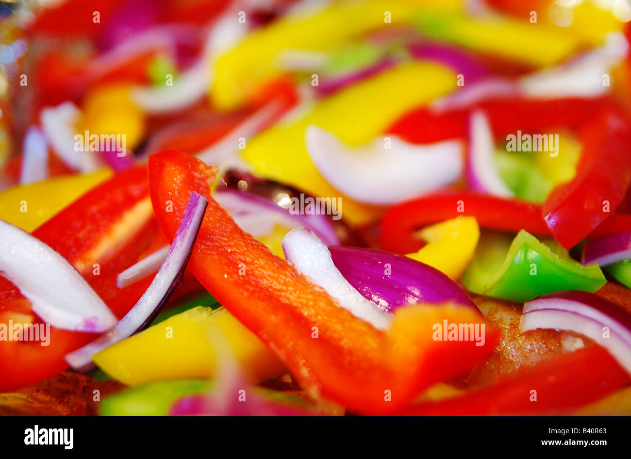 Red, Green, Yellow Peppers chopped up with Red Onions Stock Photo