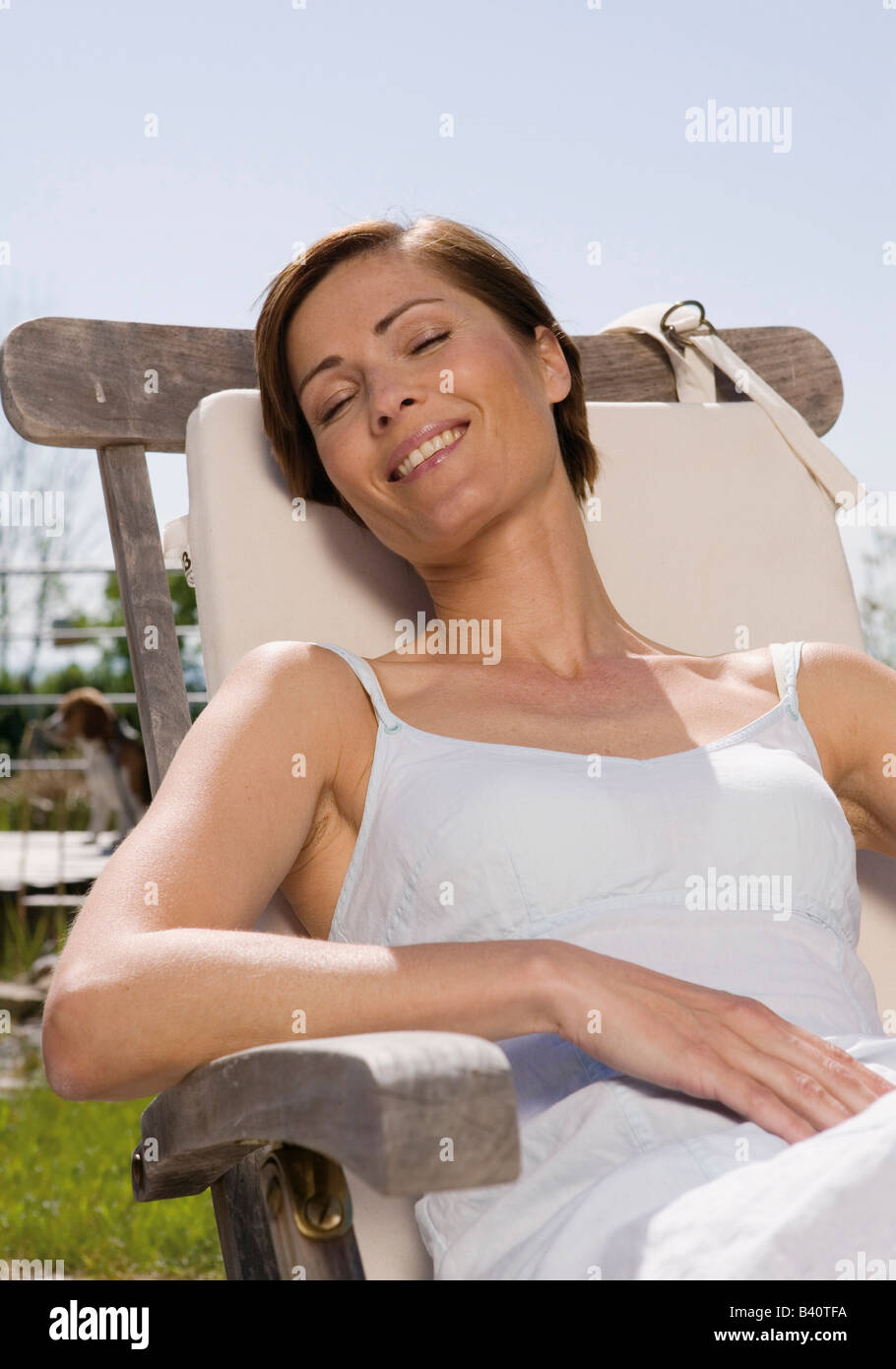 Mature woman with closed eyes sitting in a lawn chair Stock Photo - Alamy