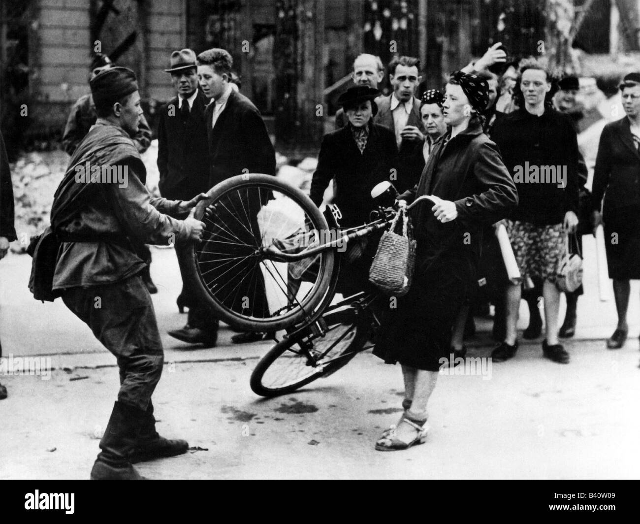 events, Second World War / WWII, Germany, end of war, Soviet soldier taking bicycle of a German woman, Berlin 1945, Stock Photo