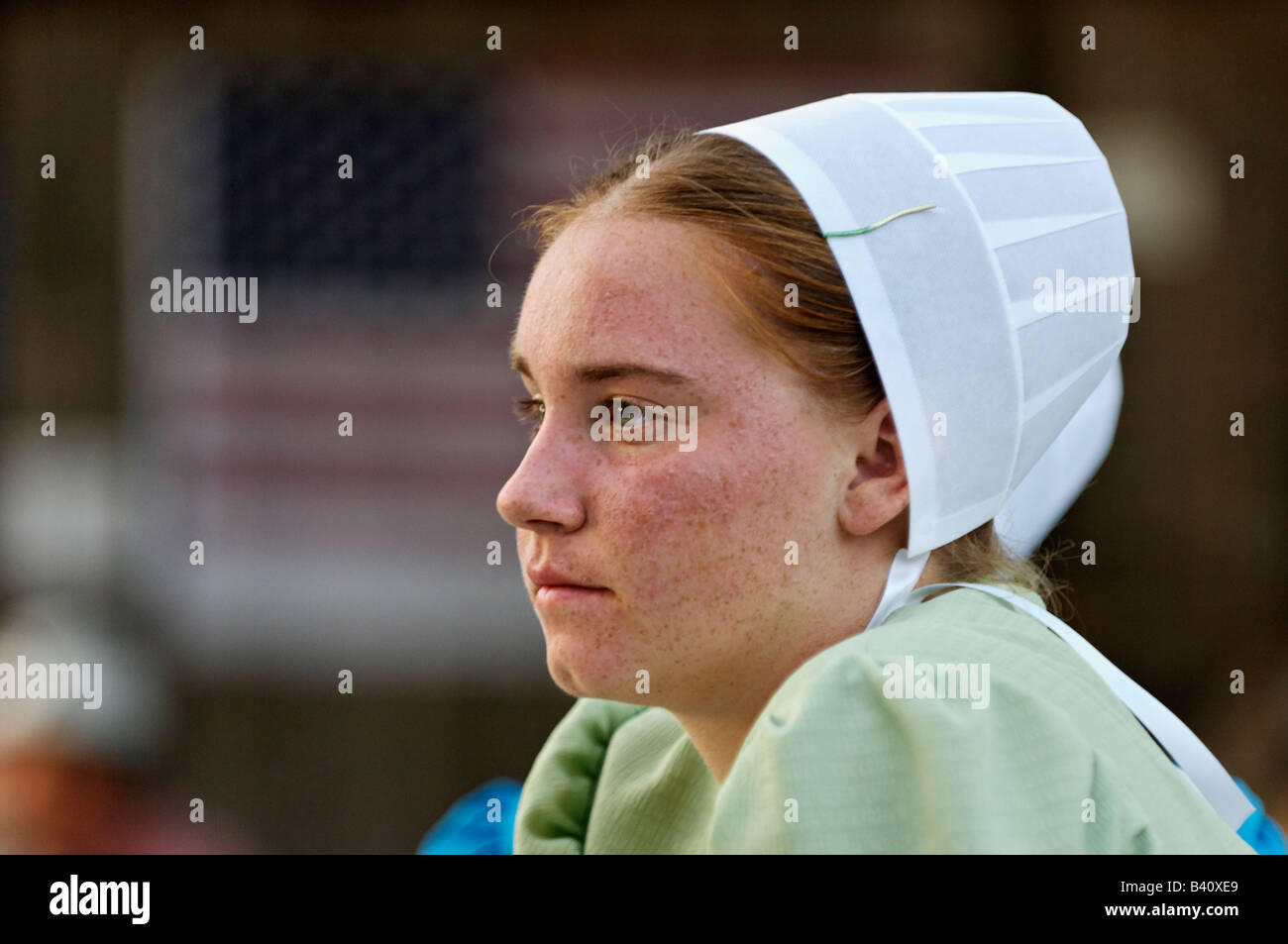 Mennonite Teenage Girl at Heritage Festival with American Flag Behind Lanesville Indiana Stock Photo