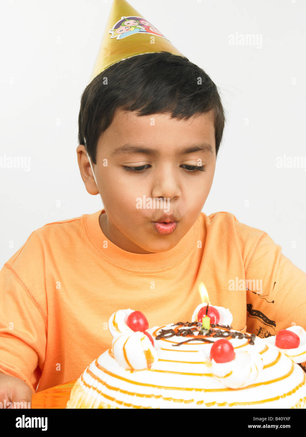asian boy of indian origin blowing the candle on his birthday cake Stock Photo Alamy