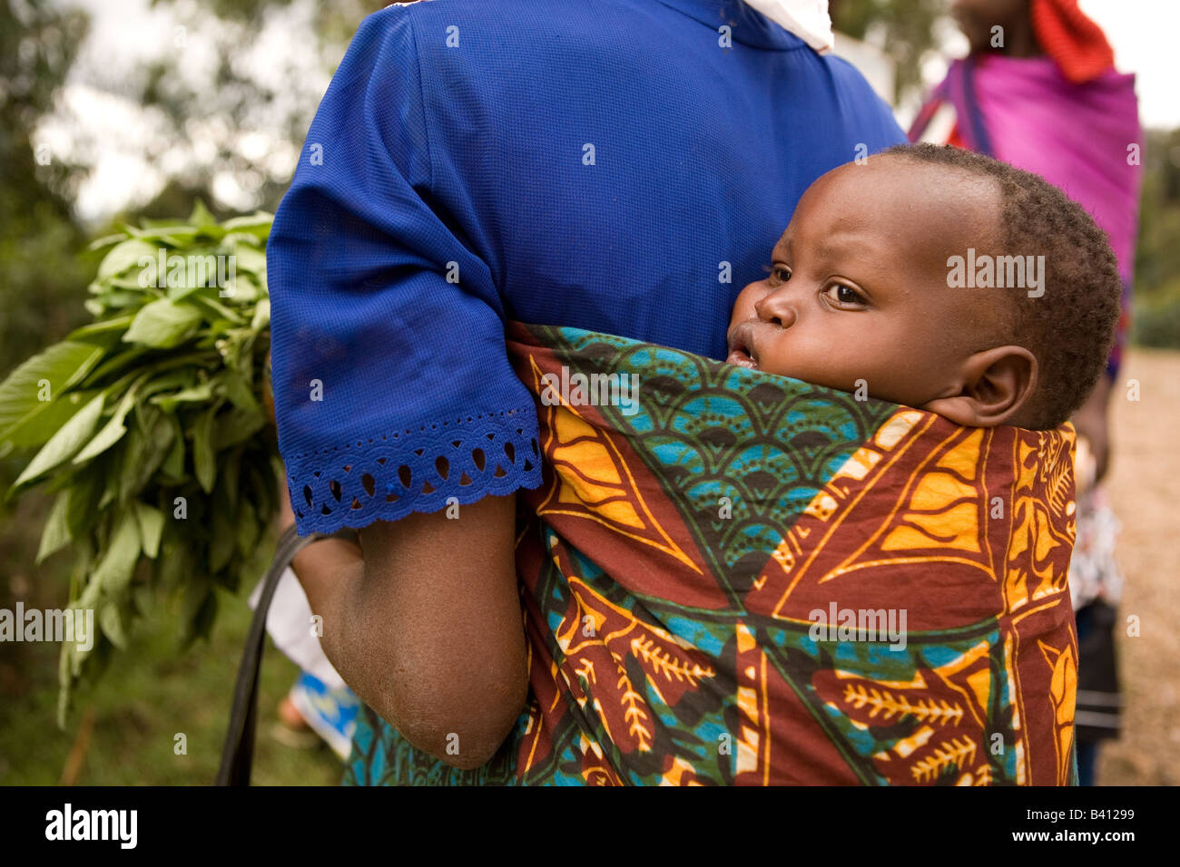 A Rwandan baby tied to its mother's back with a cloth called an "igitengeh  Stock Photo - Alamy