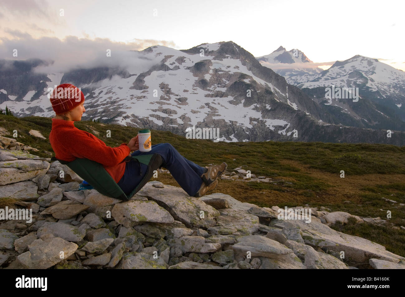 USA, Washington, Cascade Mountains, North Cascades NP.  A female hiker relaxes at camp.  (MR) Stock Photo