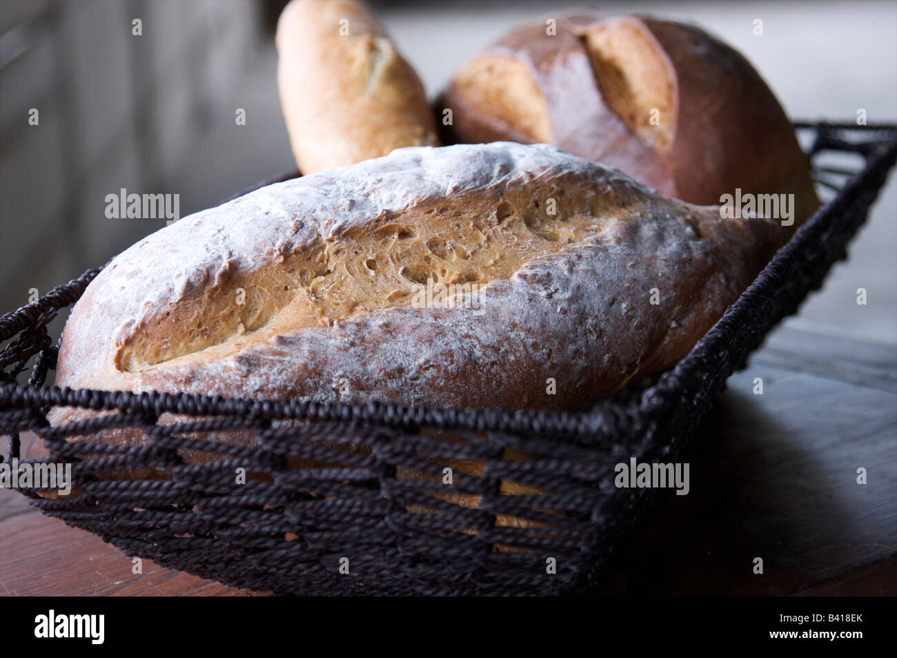 Three freshly baked loafs of bread in a basket Stock Photo
