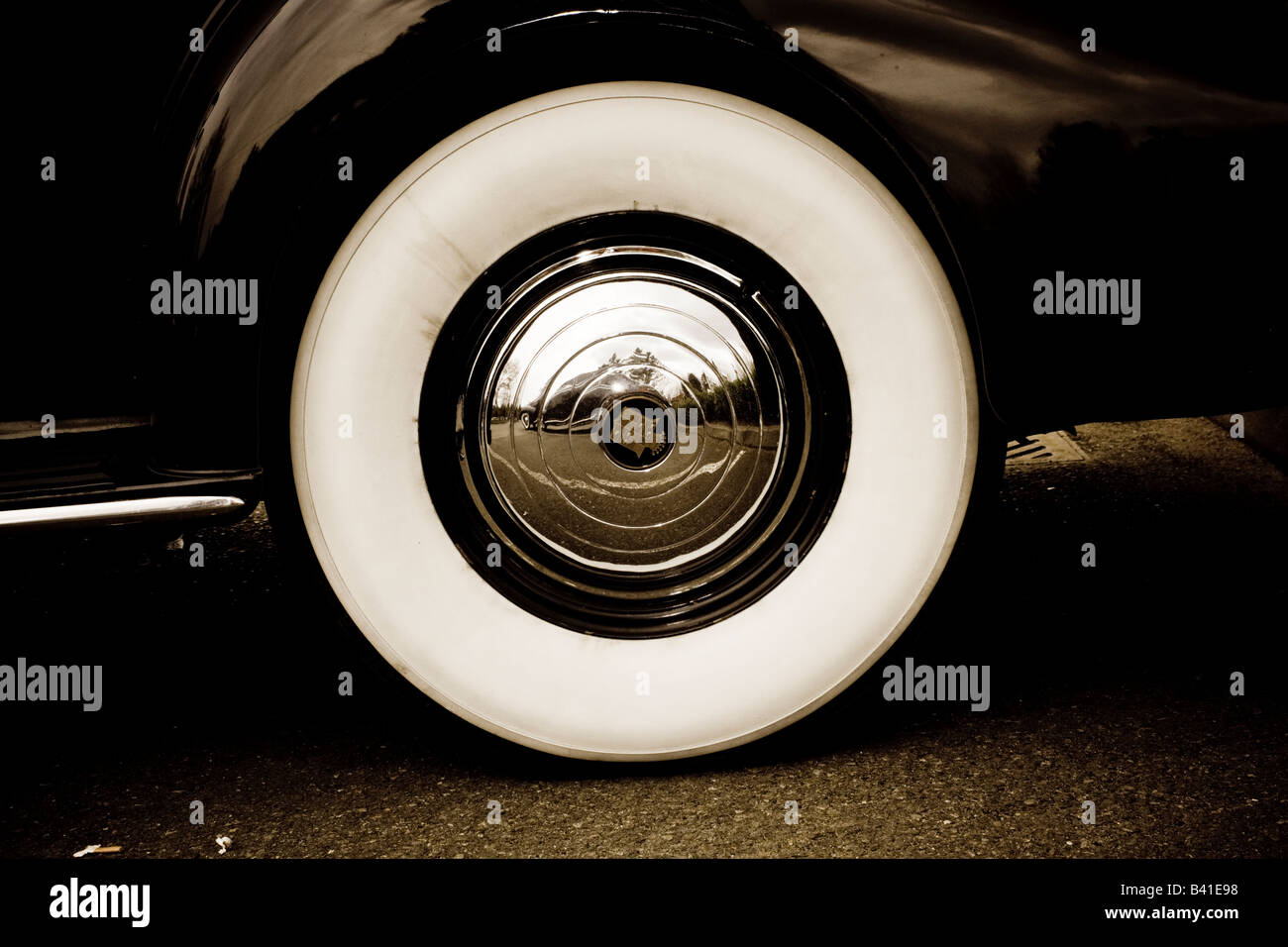 Classic Cadillac wheel with white wall tyres and polished hub caps. Stock Photo