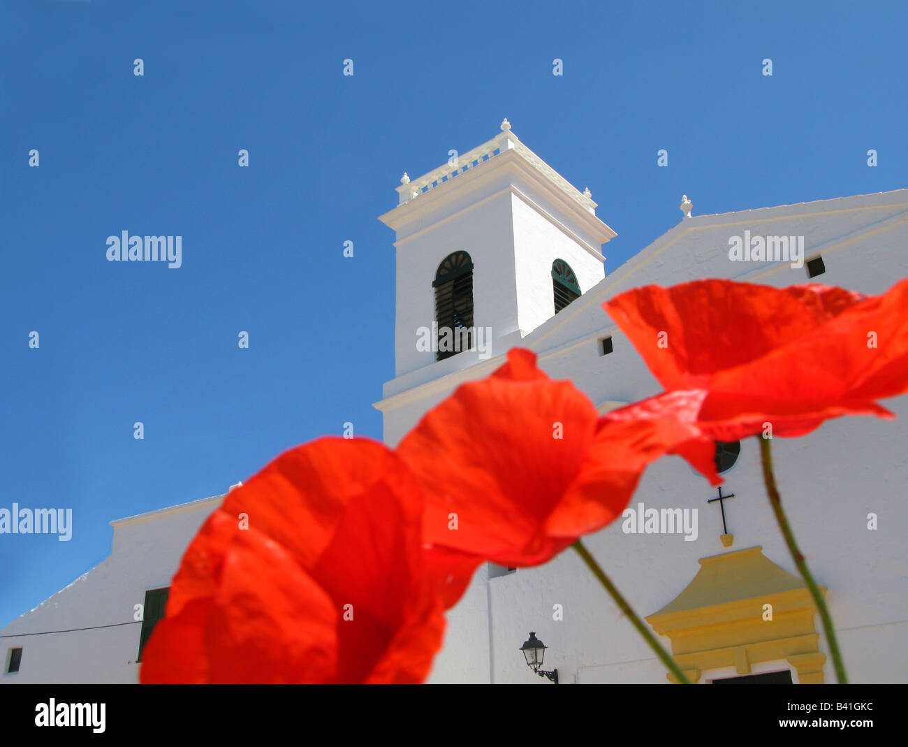Red poppies below the church of Sant Martí, Mercadal, Menorca, Spain Stock Photo