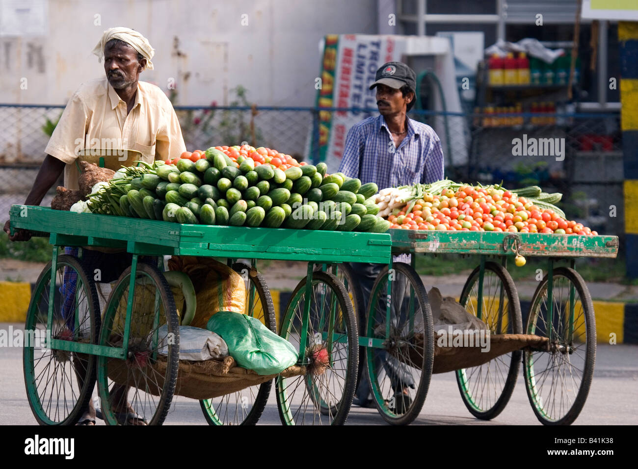 Men push handcarts bearing fruit and vegetables in Mysore, India Stock