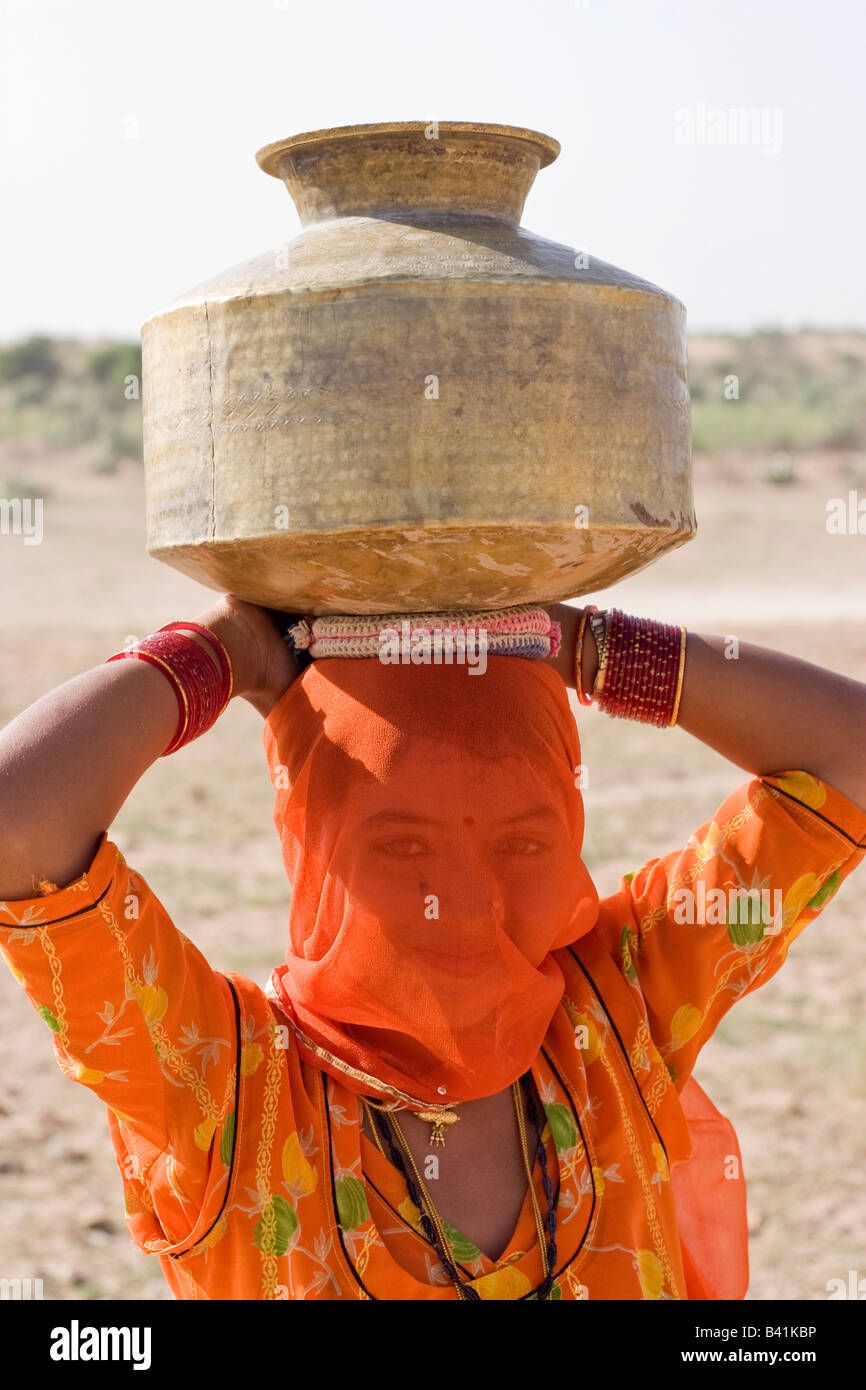 A Woman on her way to collect water from small water pond. Thar desert, Rajasthan, India. Stock Photo