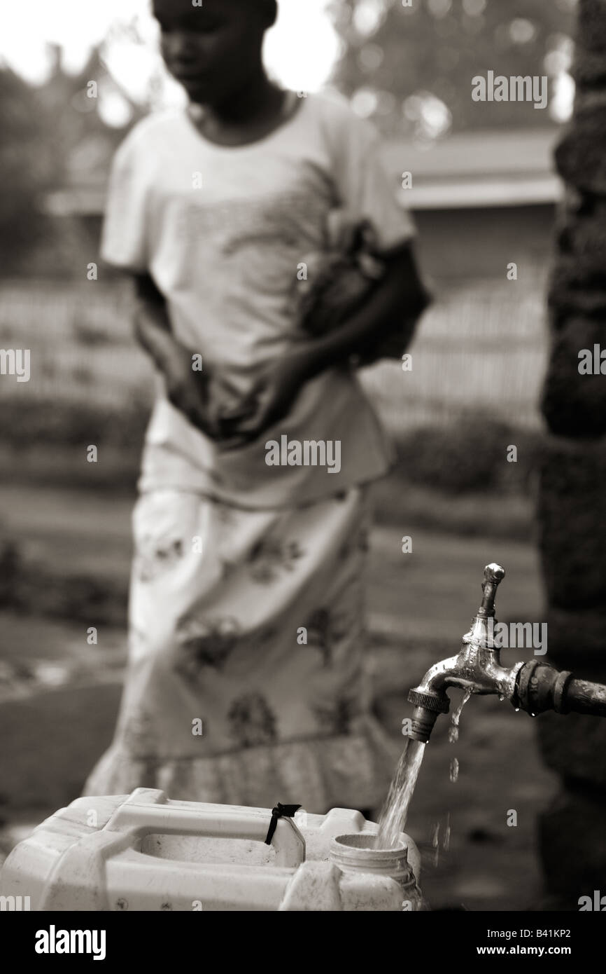 A Young Girl Waits Patiently While Her 20 Liter Jerry Can Fills With