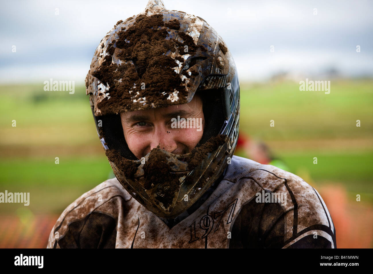 man with crash helmet covered in dirt involved in motocross racing