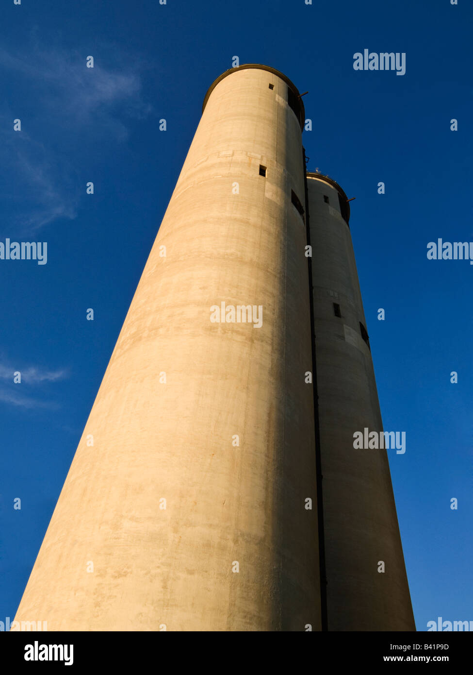 Two industrial towers standign together against clear blue sky Stock