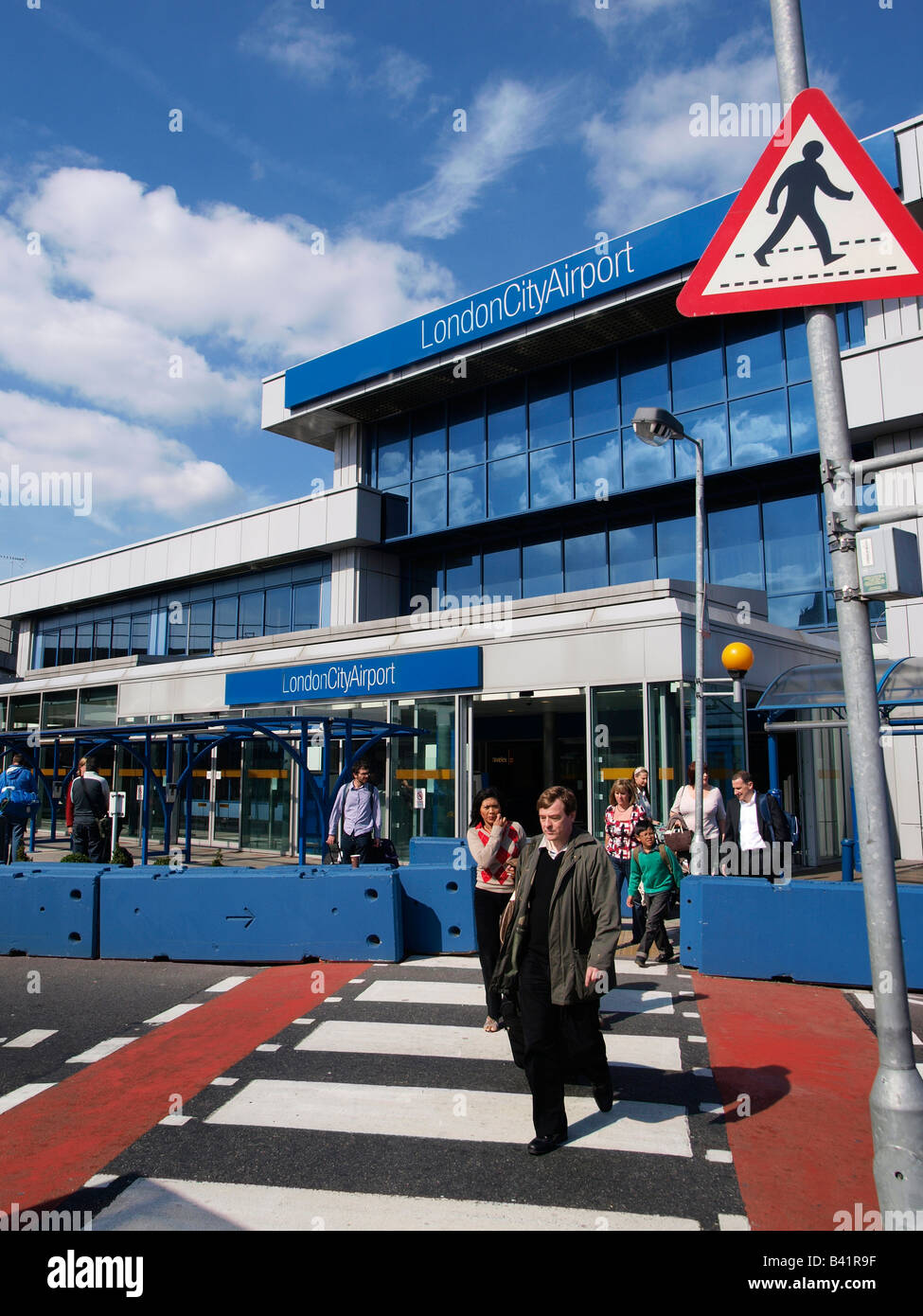 London City Airport terminal exit entrance with people crossing the street London UK Stock Photo
