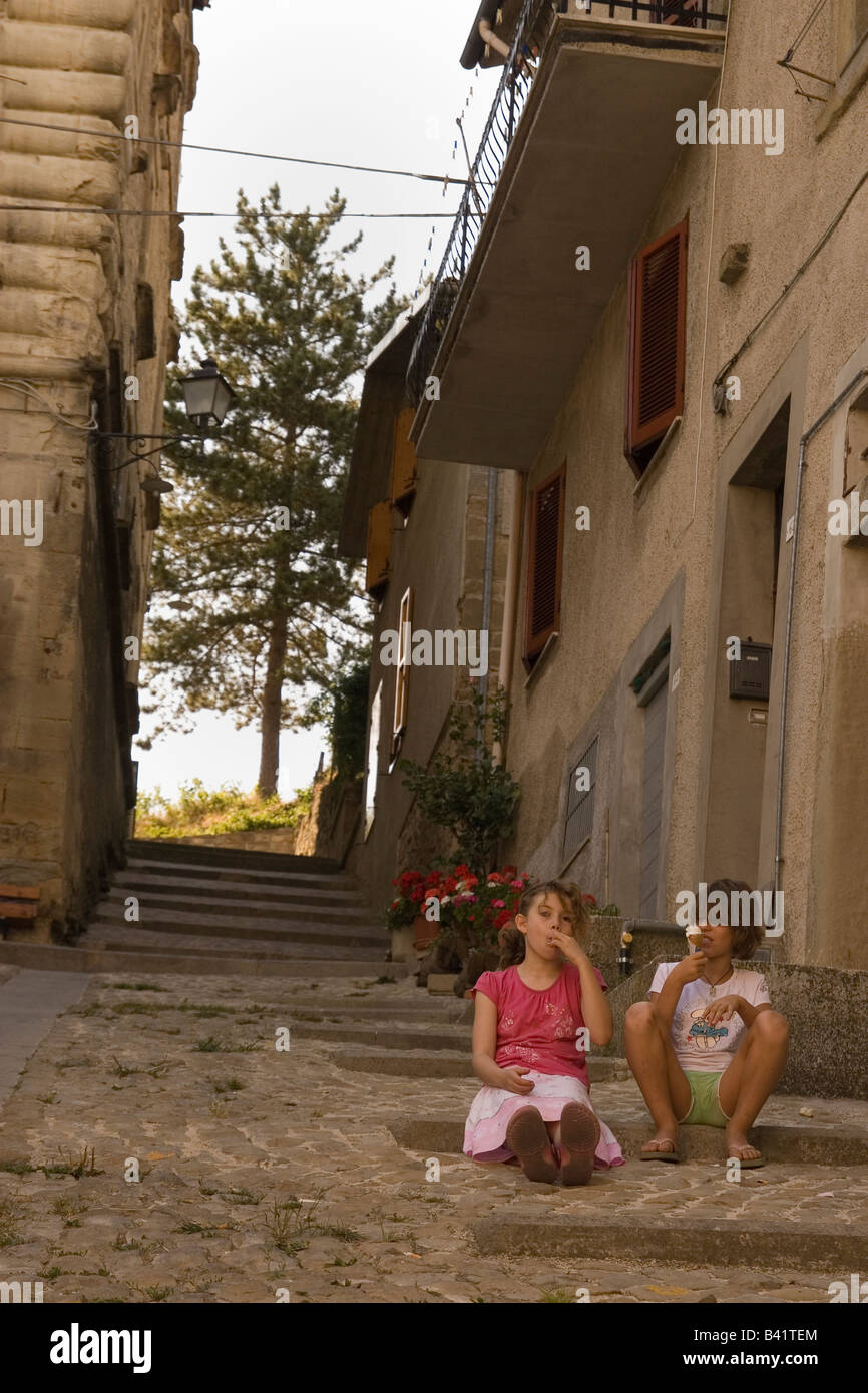 girls eating ice cream in 12th century street in Accumoli italy Stock Photo