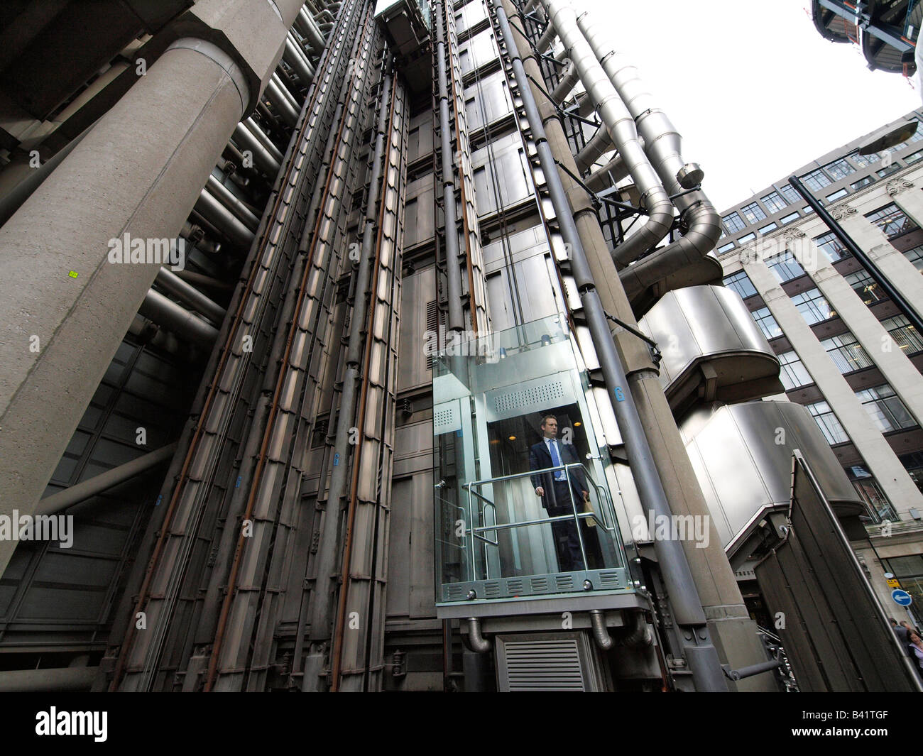 Man inside glass external elevator of the Lloyds building in the London city UK Stock Photo
