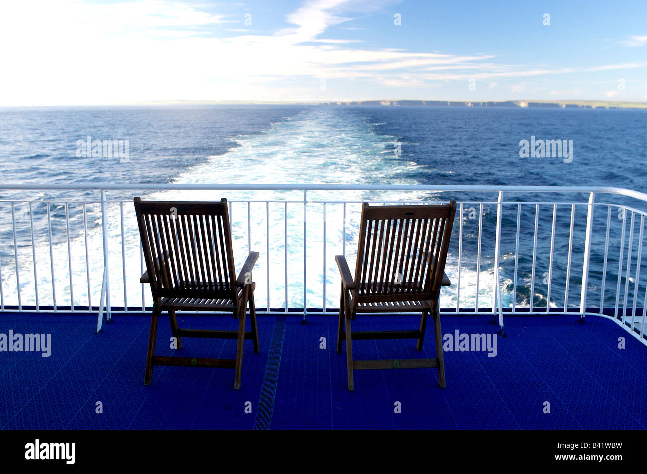 Two deck chairs looking where the boat has been, Stock Photo
