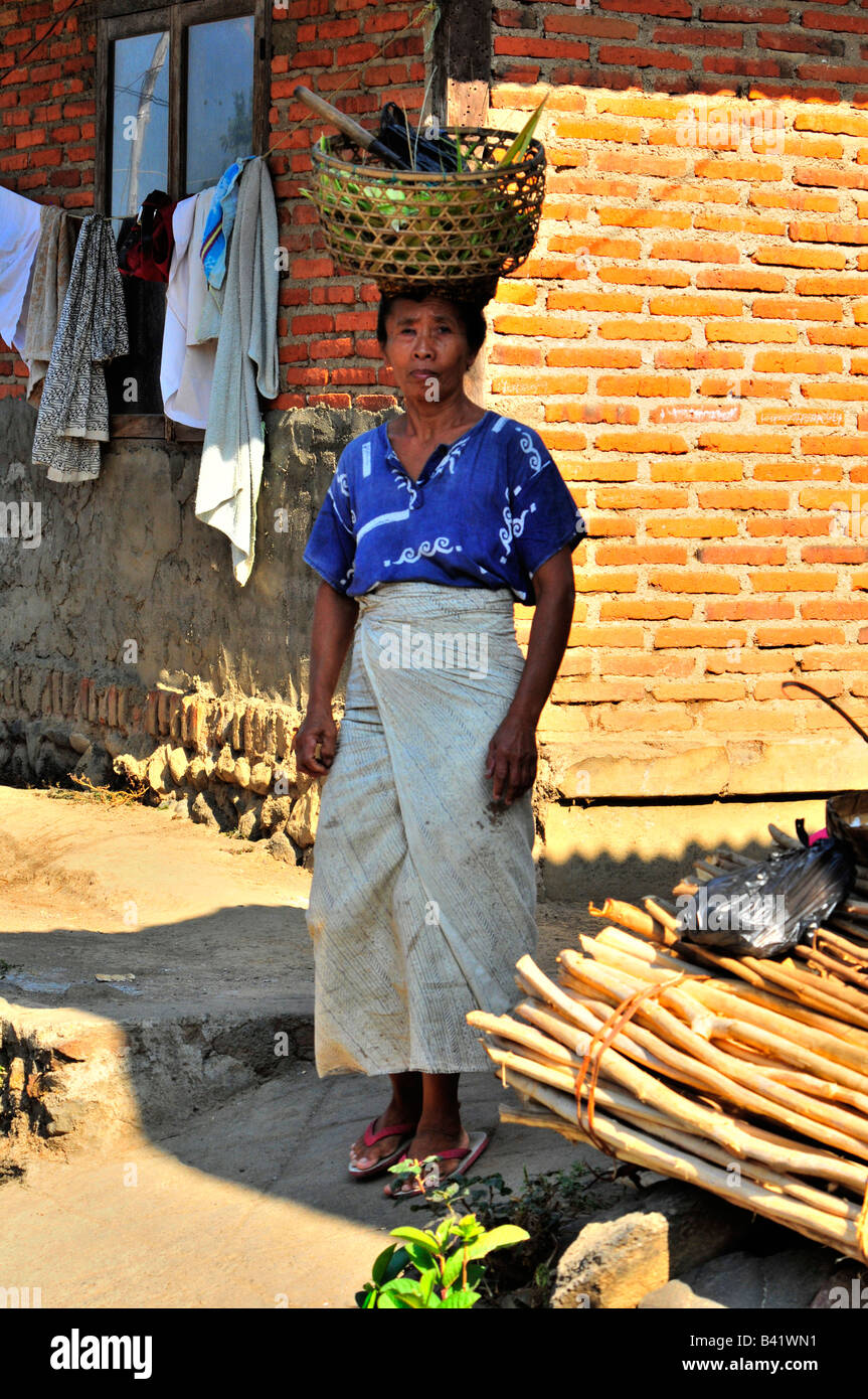 bali aga village life, lady street worker carrying tools on her head, semberan, bali aga village , north bali , indonesia Stock Photo