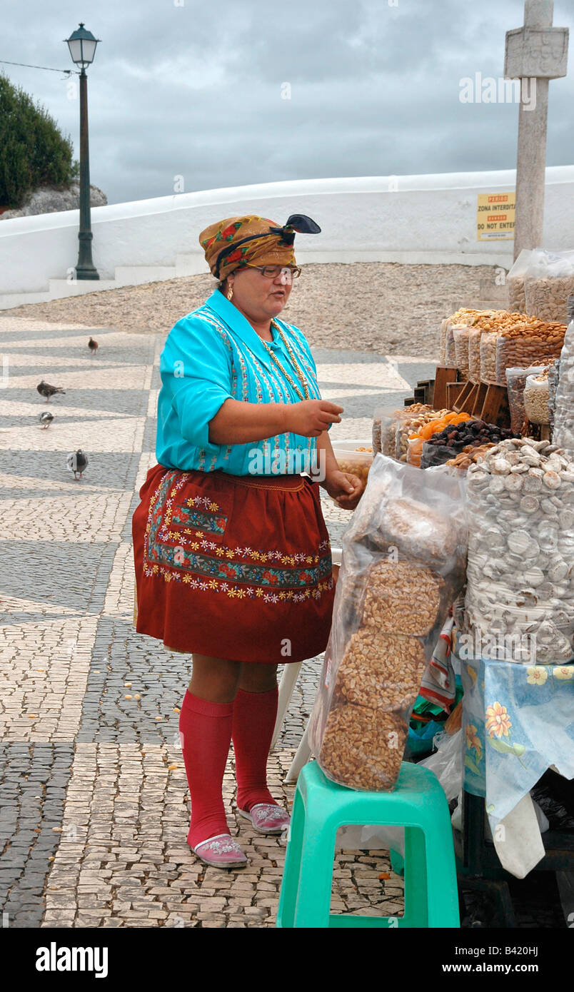 A woman sells nuts and dried fruit at an open stall in Nazare, Portugal