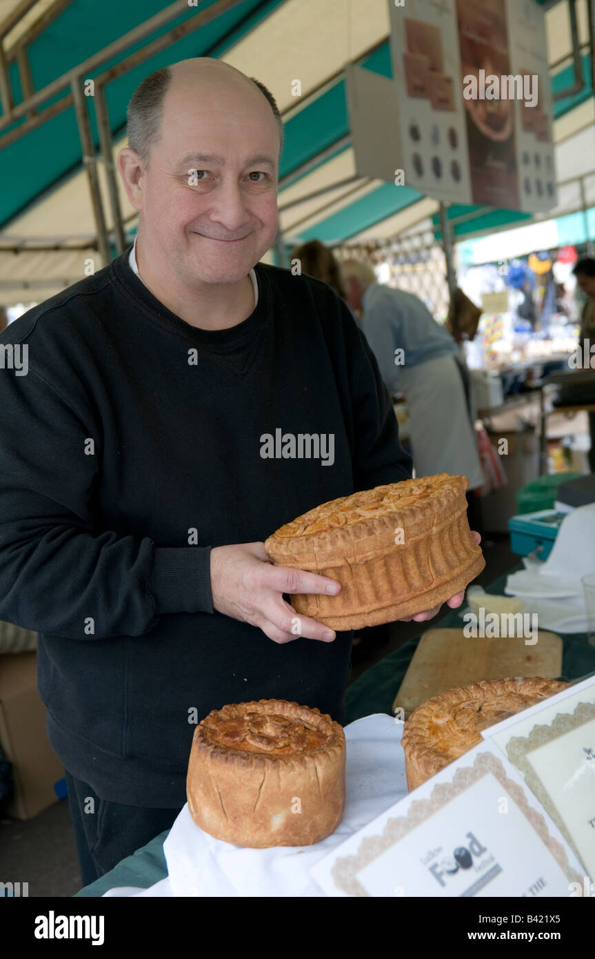 male stallholder with a large fresh pork pie at the Food festival Ludlow Shropshire England UK Stock Photo