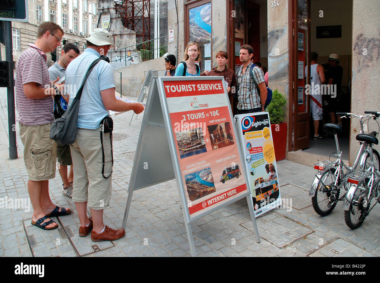 A group of tourists  consult a map while standing outside a tourist information centre in Portugal. Stock Photo