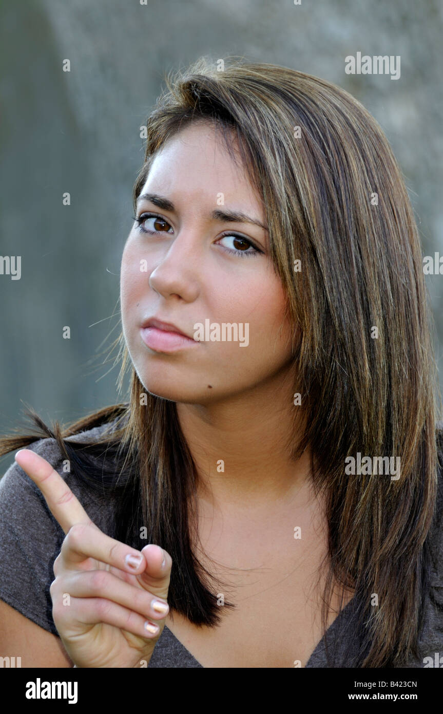 Conceptual image A pretty caucasian 16 year old girl points her finger in anger. Stock Photo