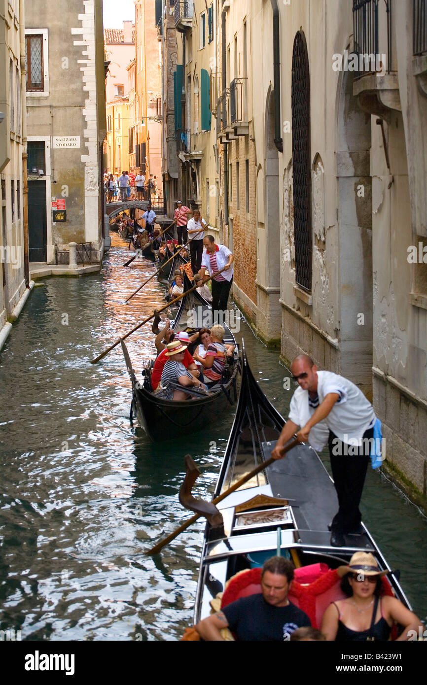 Taking a Gondola ride through narrow canals in Venice Stock Photo