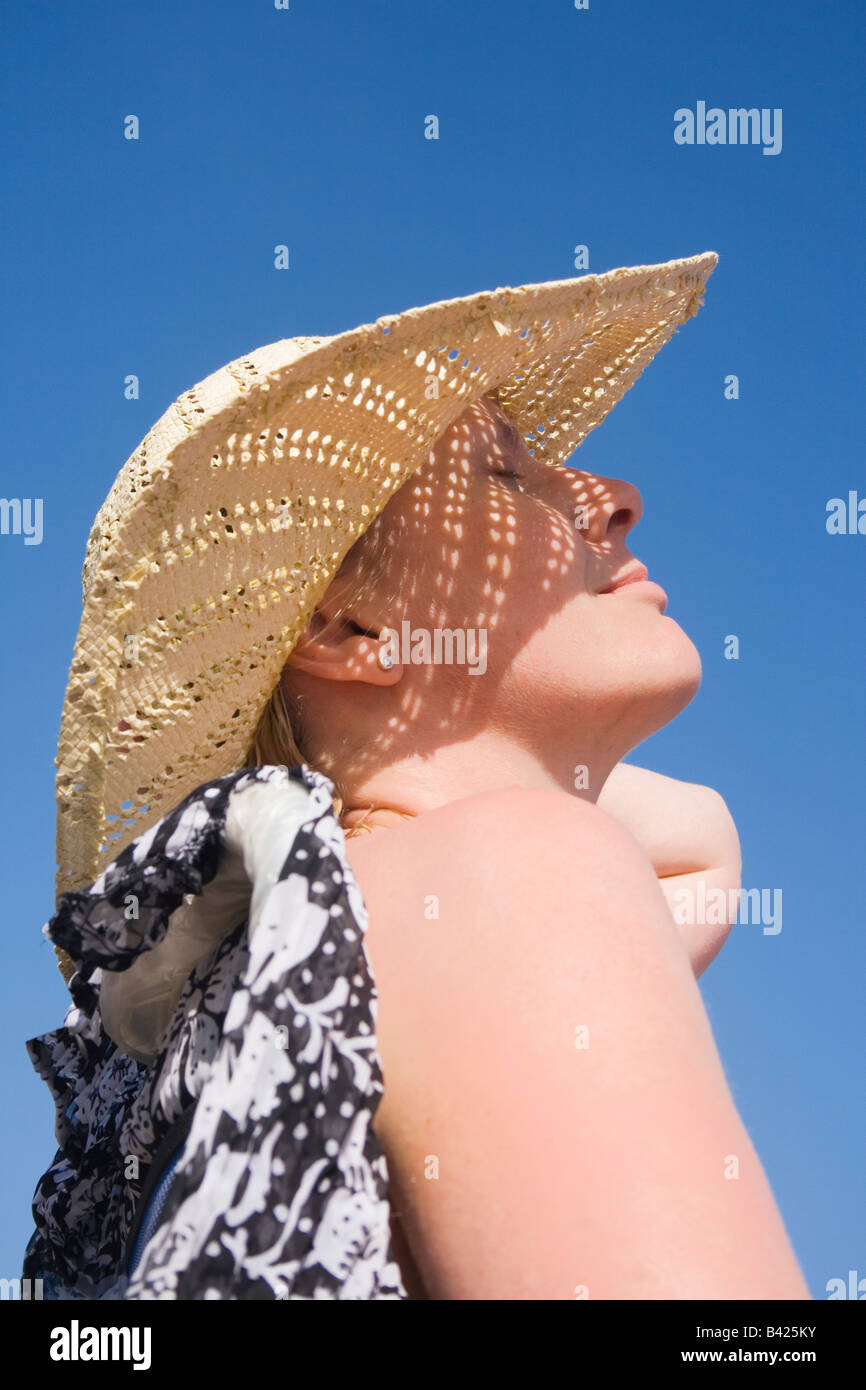 Woman in hat sunbathing Stock Photo