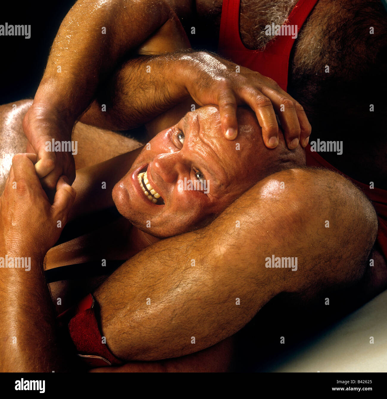 WRESTLING perspiring wrestlers getting to grips with each other during a wrestling match setup for advertising image Stock Photo