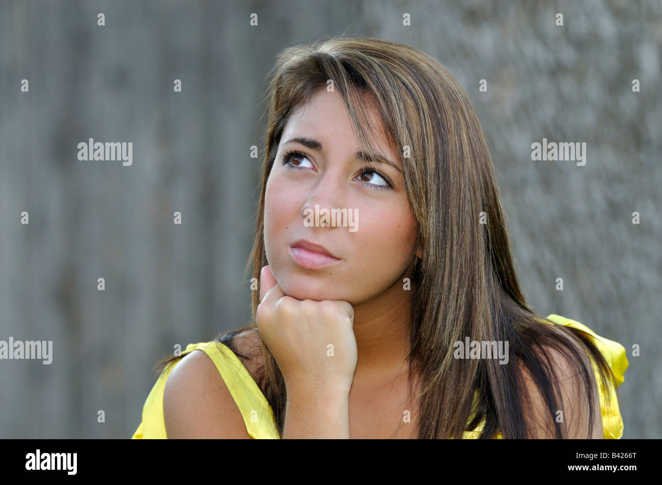 A pretty caucasian 16 year old girl has an expression of perplexity or wondering or thinking. Conceptual image. Stock Photo