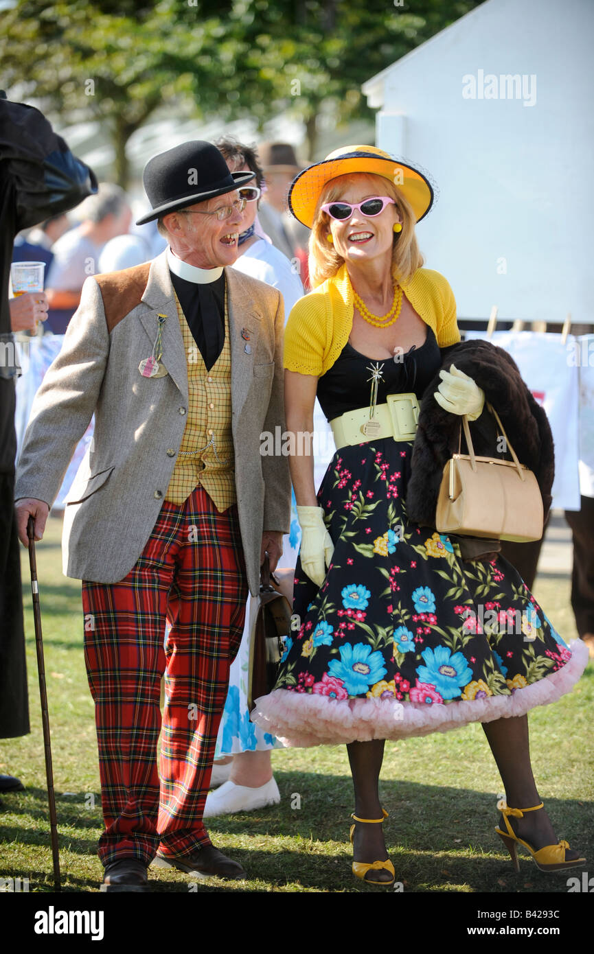 Goodwood Revival 2008: A vicar enjoys a giggle with guest in bright outfit. Stock Photo