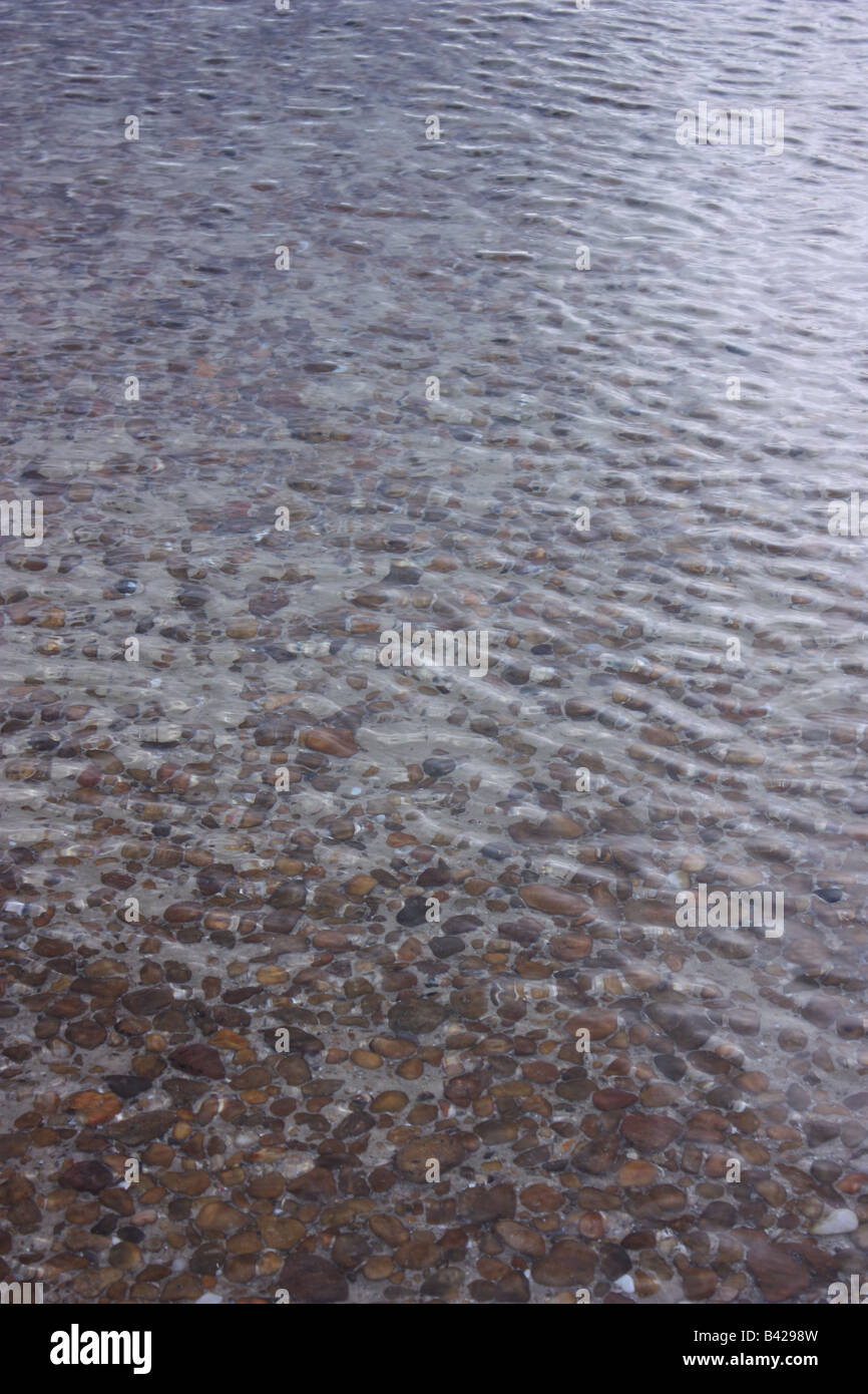 stones under seawater with a transparent view fading to a glassed and rippled sea view Stock Photo