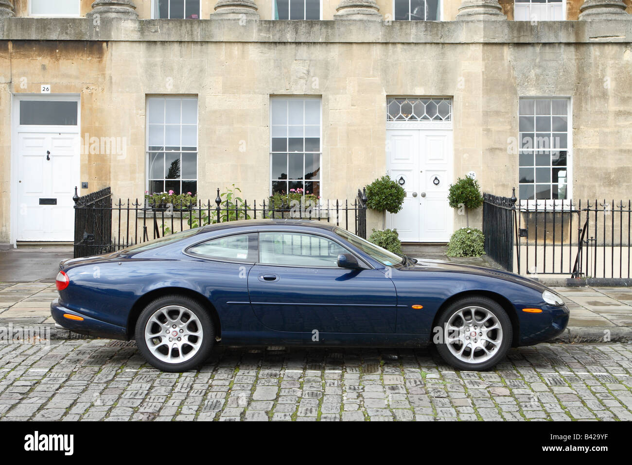 Jaguar XKR expensive sports coupe car parked on cobbles in The Royal Crescent in Bath England in Autumn Stock Photo