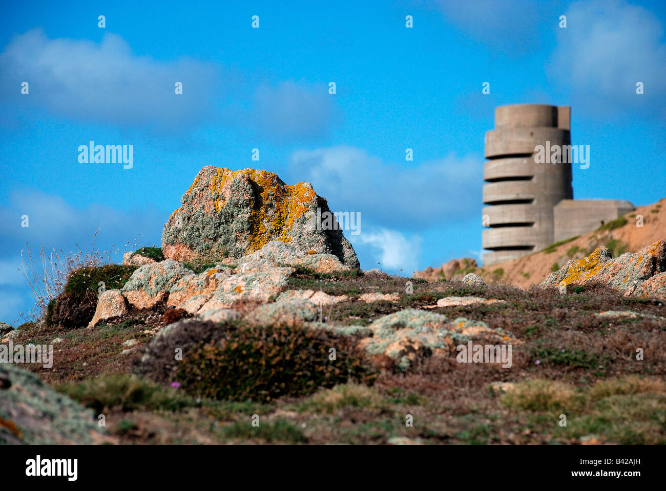 WW2 german look-out tower on north jersey coast with lichen covered rocks Stock Photo