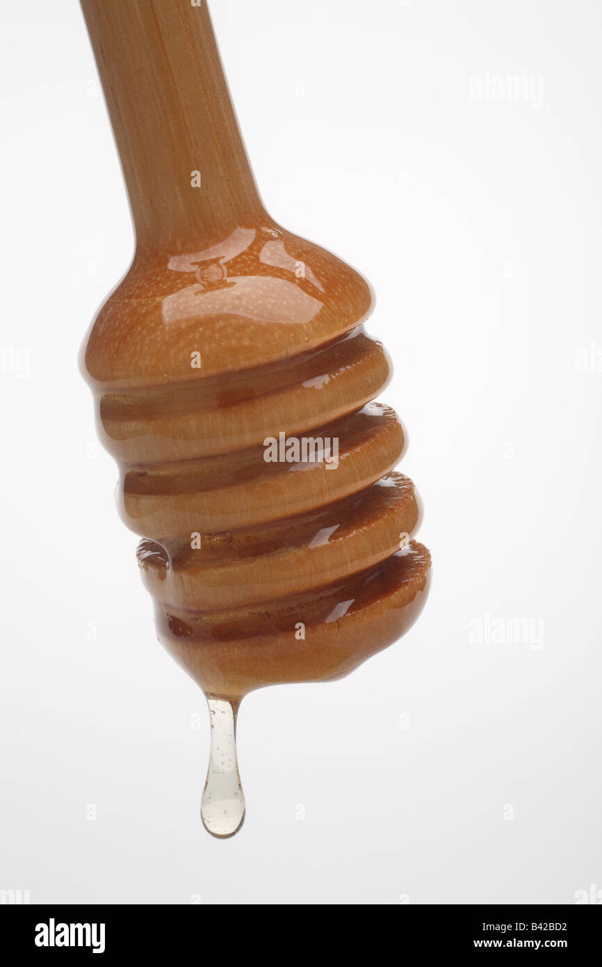 Wooden honey server with dripping honey close up Stock Photo Alamy