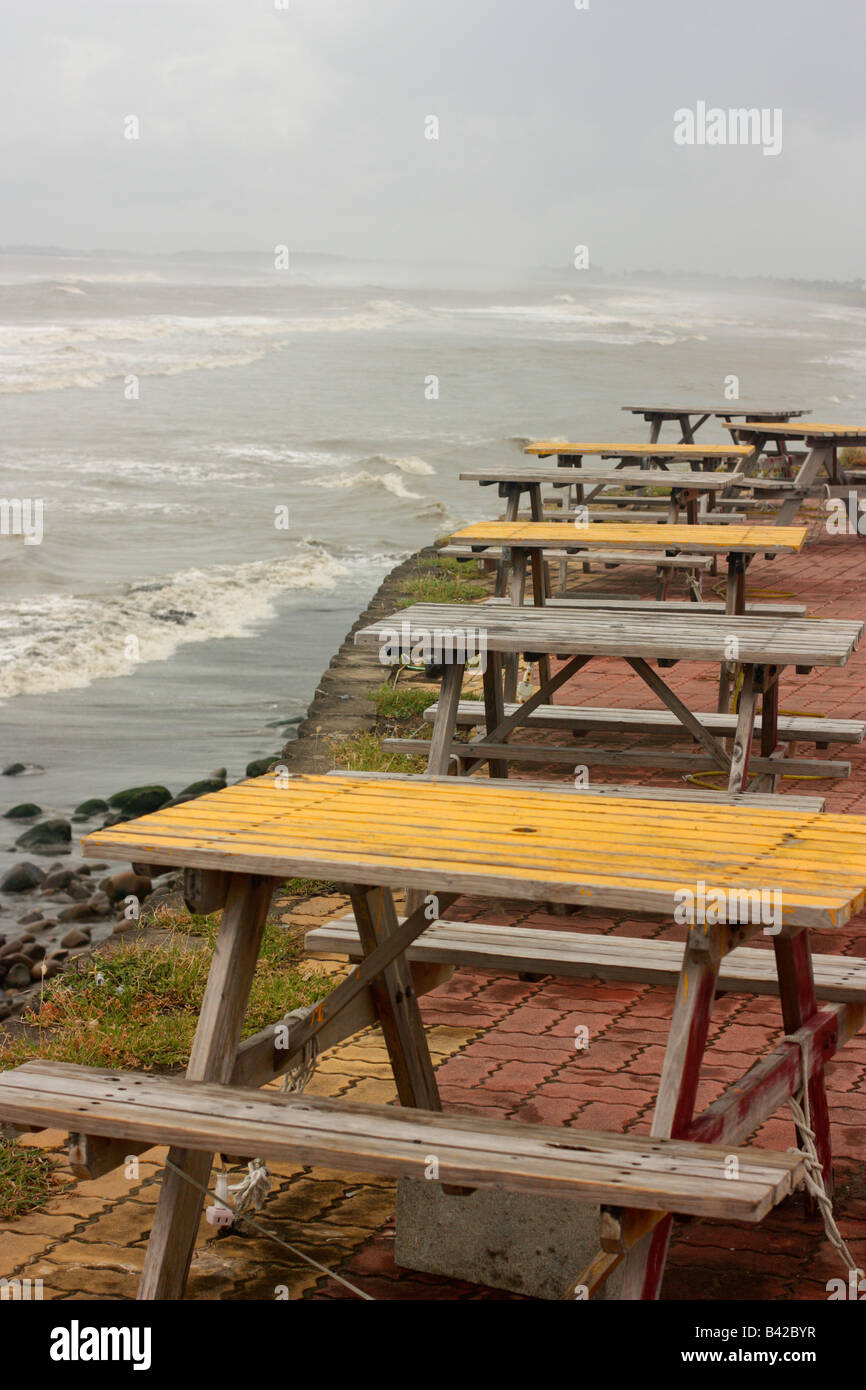 Picnic tables at a deserted beach eating area. Stock Photo