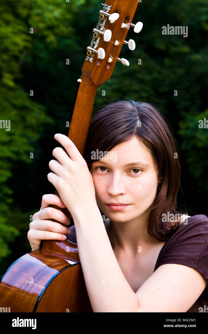 Young pretty woman holding her classic guitar Stock Photo - Alamy