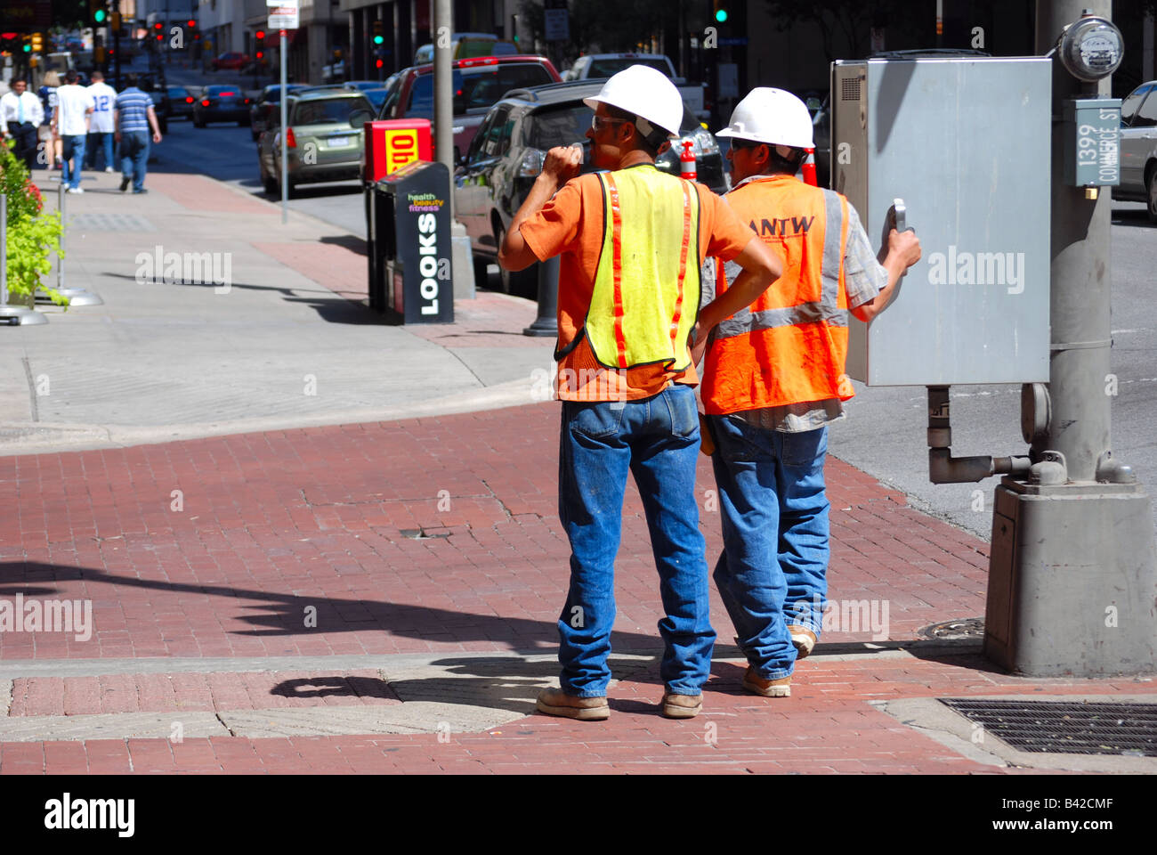 Two utility or construction workers waiting to cross the street Stock Photo