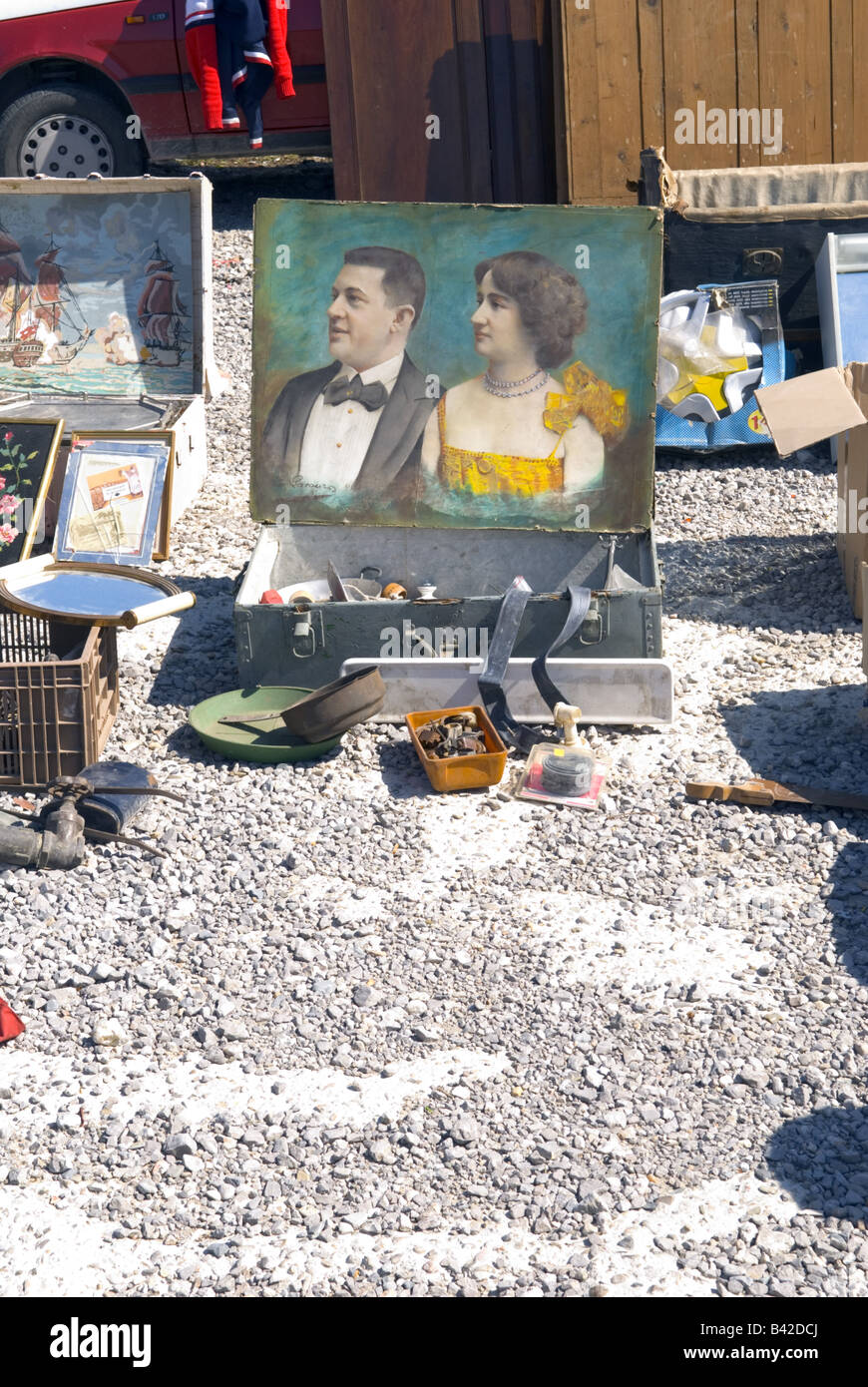 an old portrait painting of couple sits amongst junk at french 'car boot' sale Stock Photo