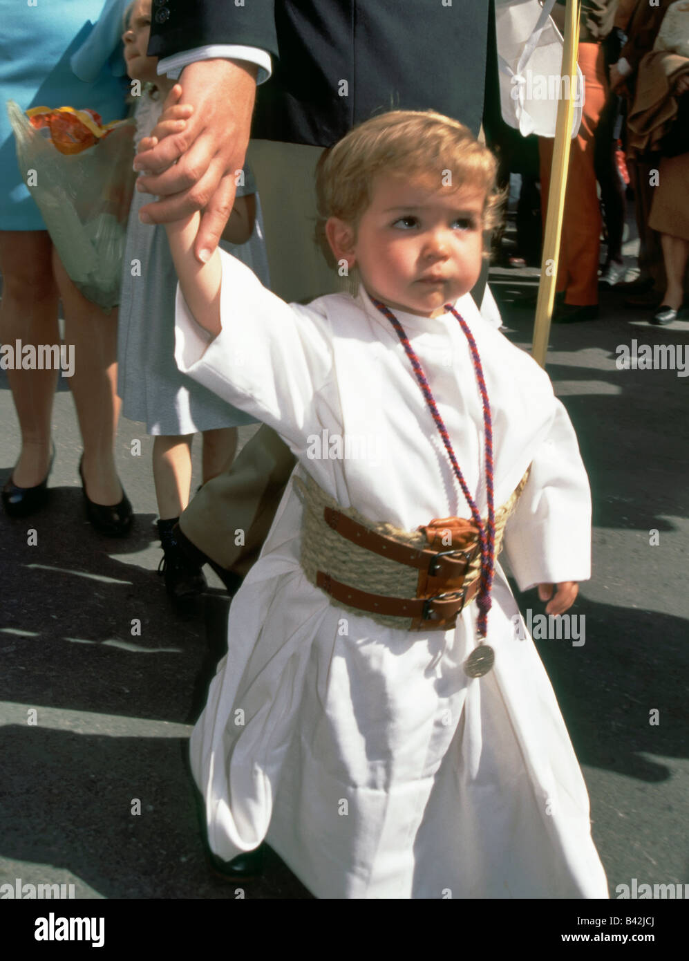 Little boy watching La Borriquita children procession during Semana Santa Holy Week in Seville Andalusia Spain Stock Photo