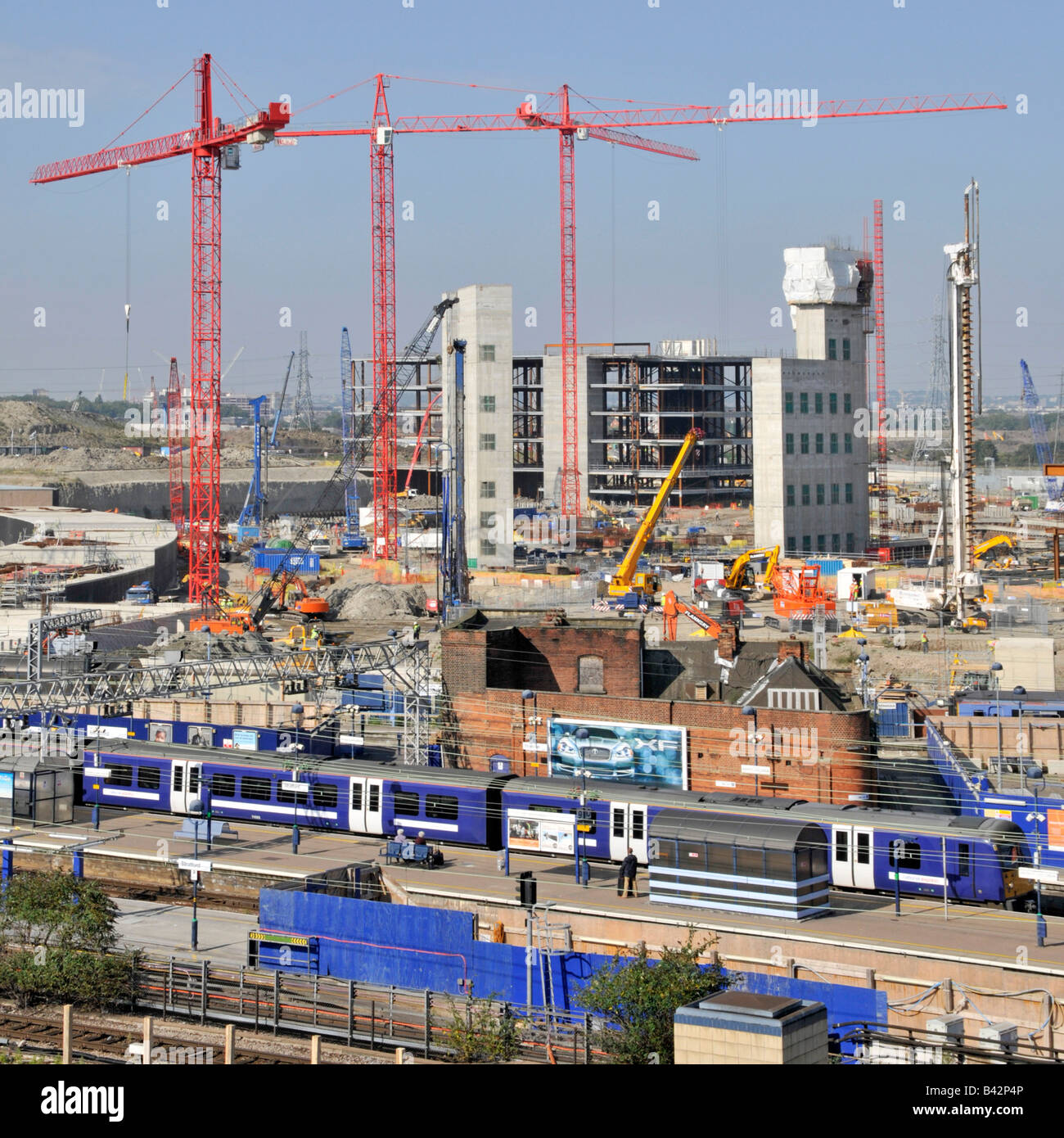 Semi aerial view of Stratford East London Westfield shopping centre complex and Olympic park building site beyond train station Stock Photo