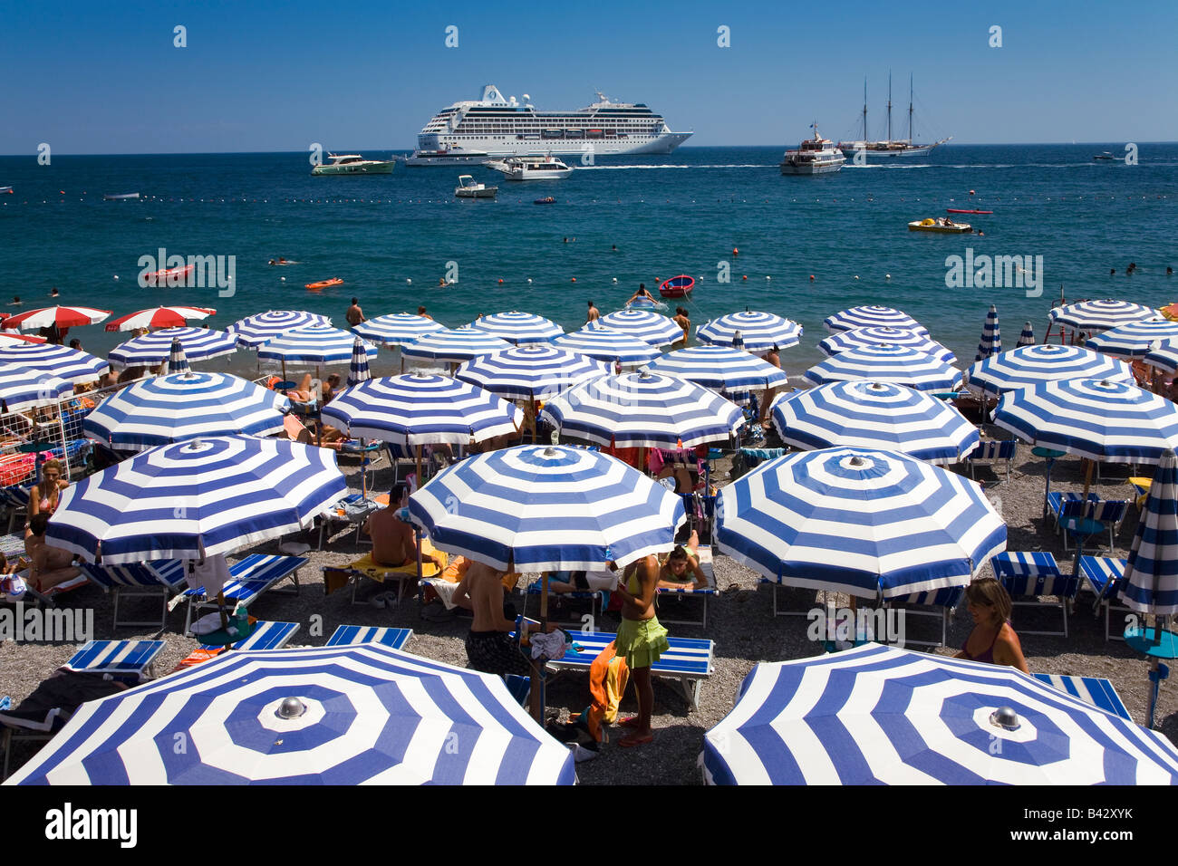 Elevated view of famous beach umbrellas of Amalfi with cruise ship in background in the province of Salerno, Amalfi, Italy, Stock Photo