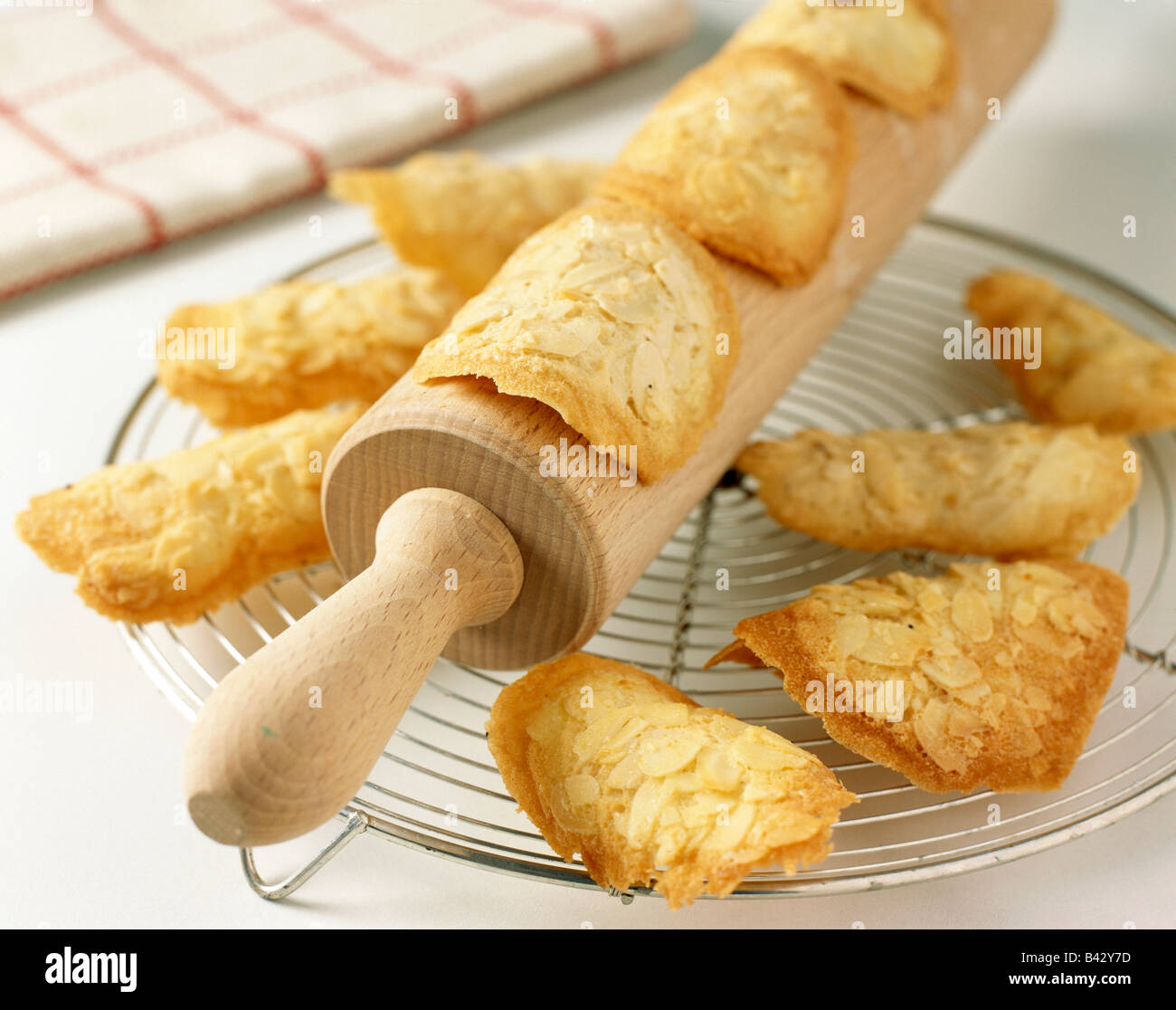 Shaping the tuile biscuits on rolling pin Stock Photo