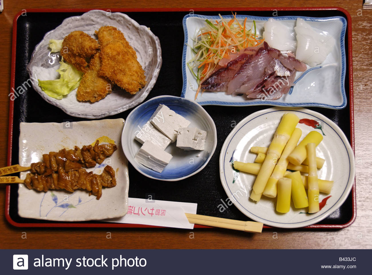 Japanese dinner set of sashimi, bamboo sprouts, tofu, skewers and Stock