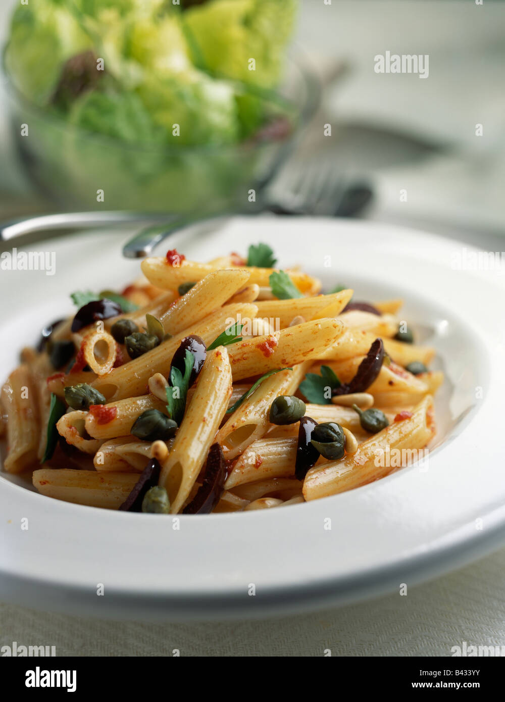 Penne with capers,olives and pinenuts Stock Photo
