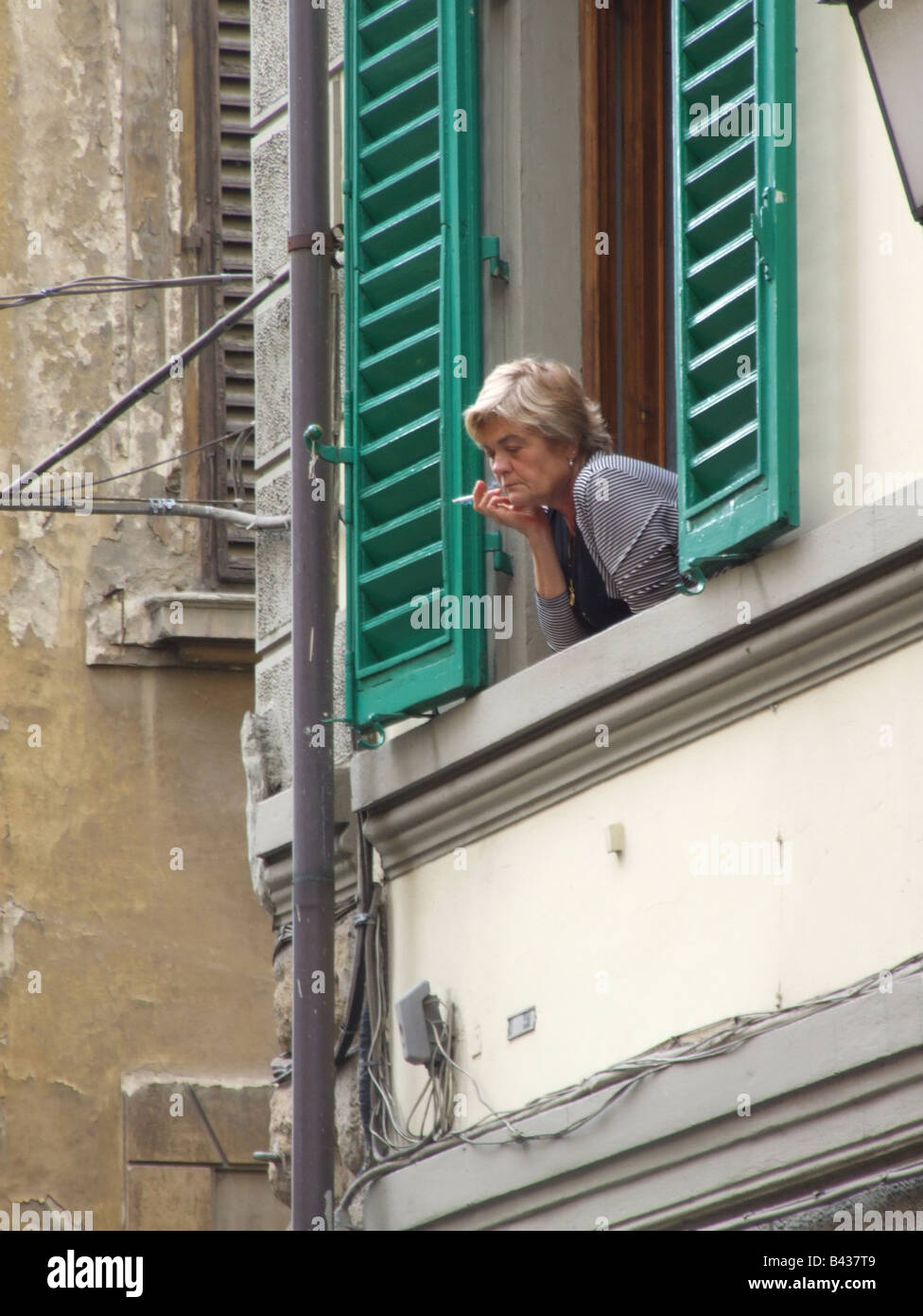 old person looking out of window in italy Stock Photo - Alamy