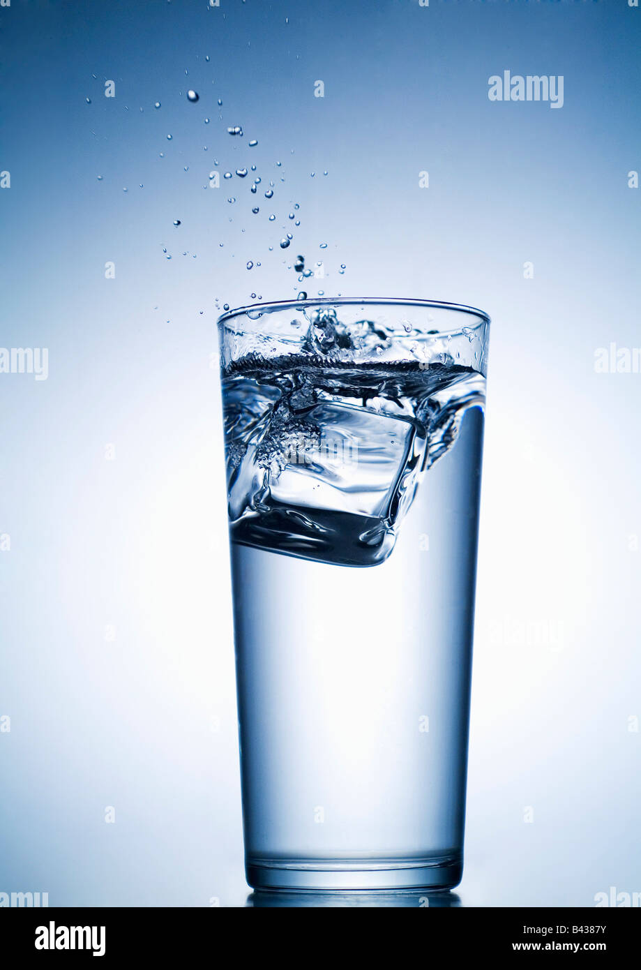 ice cube falling into glass of water Stock Photo - Alamy