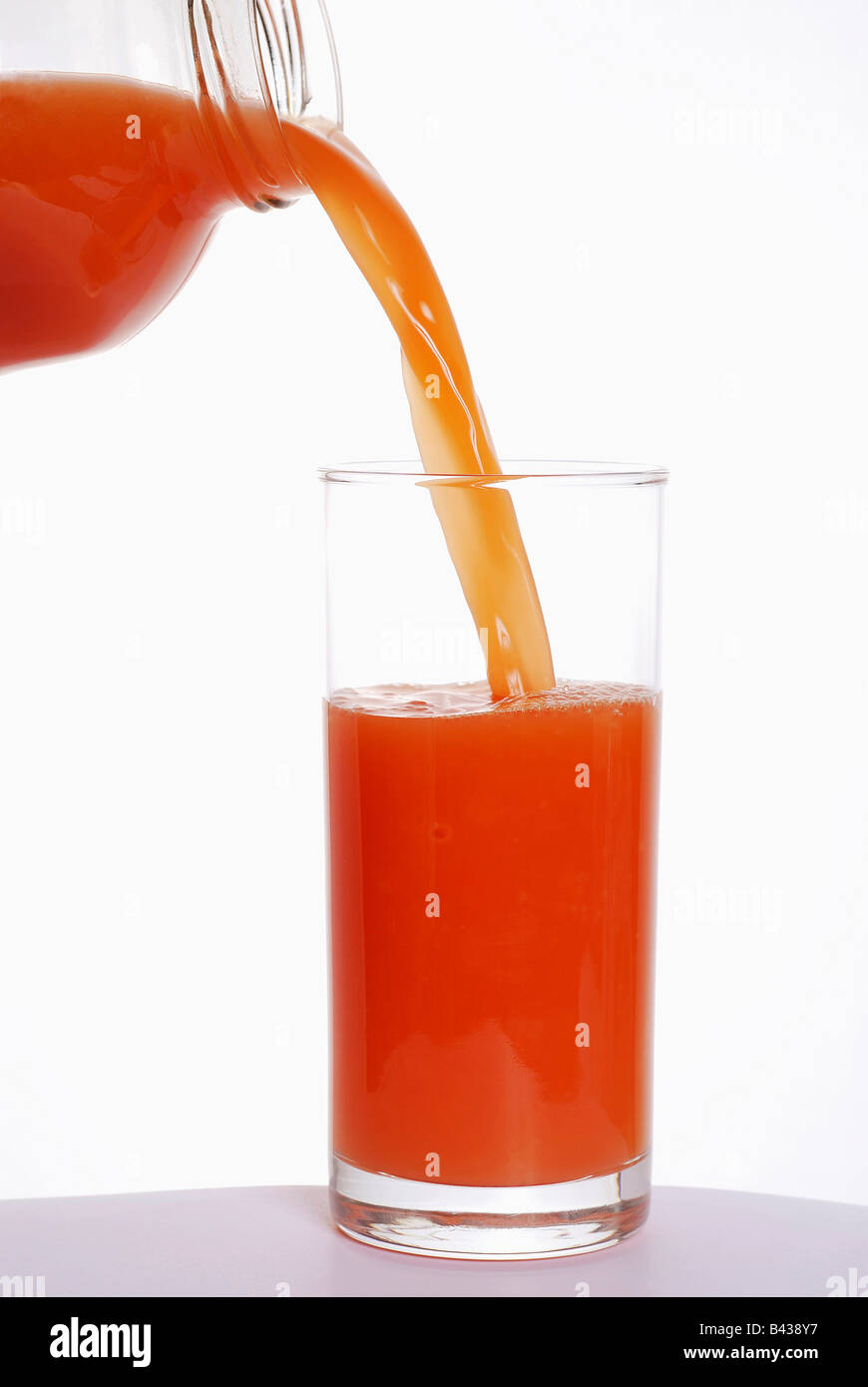 Pouring pink grapefruit juice into a glass Stock Photo
